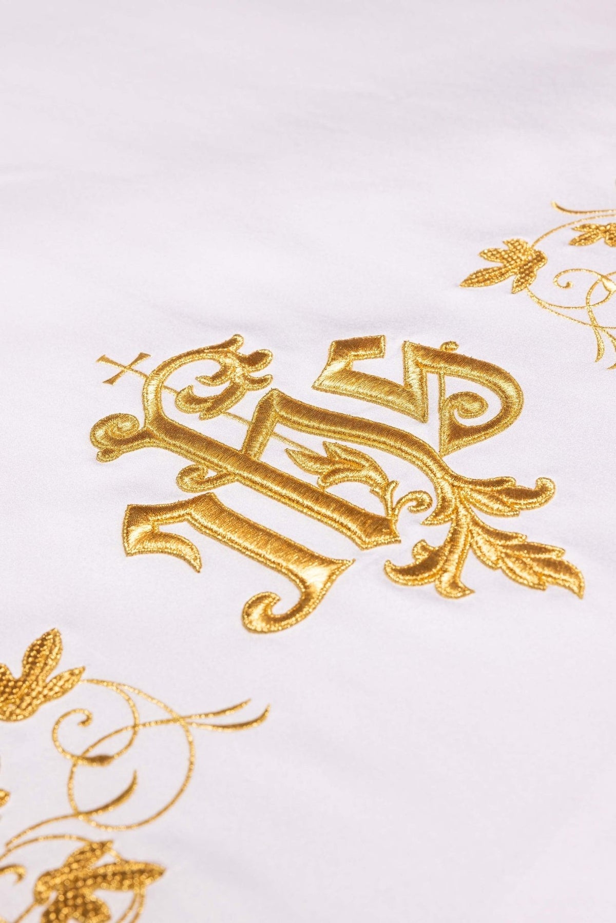 Altar cloth close-up showing the gold IHS monogram and floral embroidery