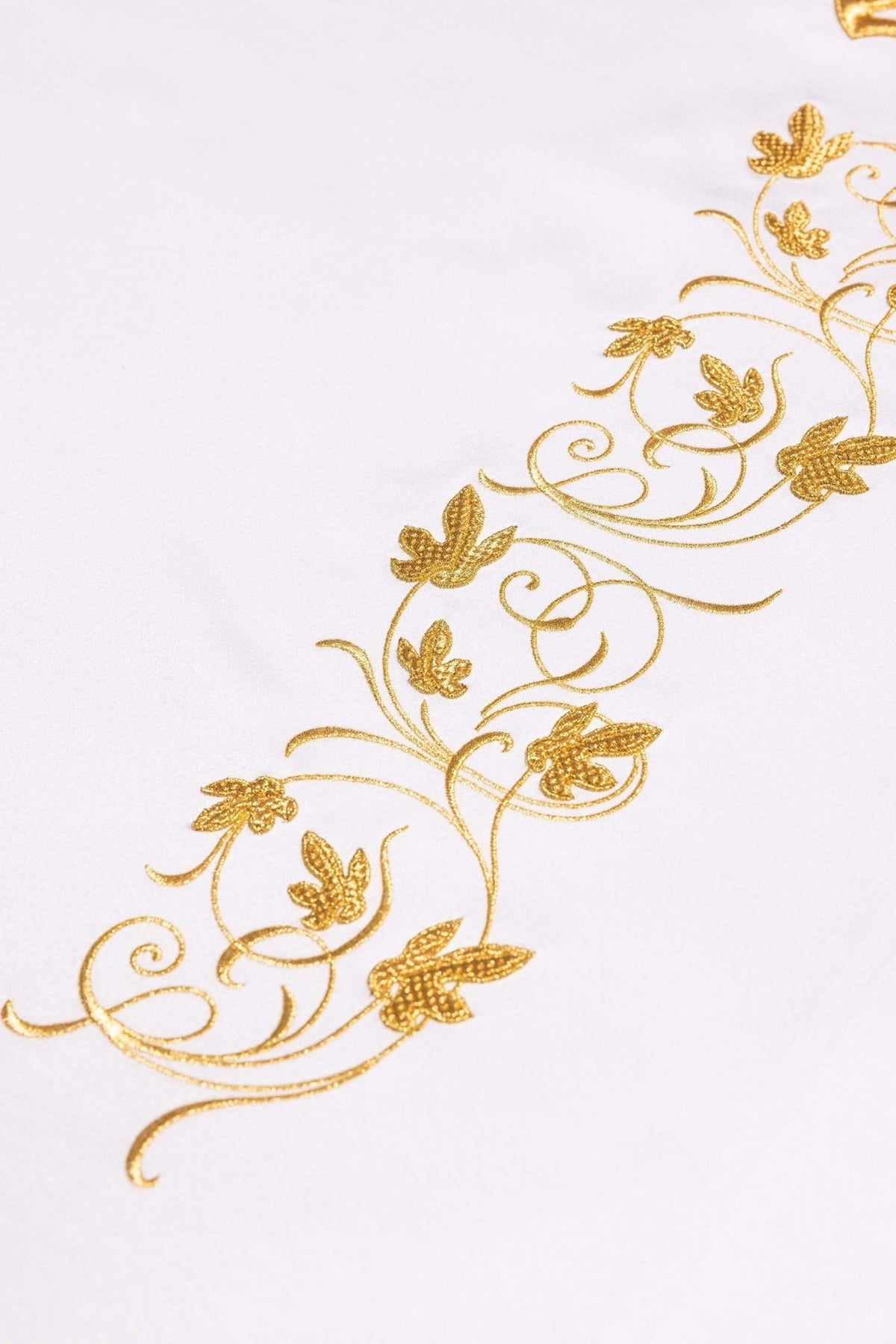 Altar cloth detail of gold floral embroidery on white fabric