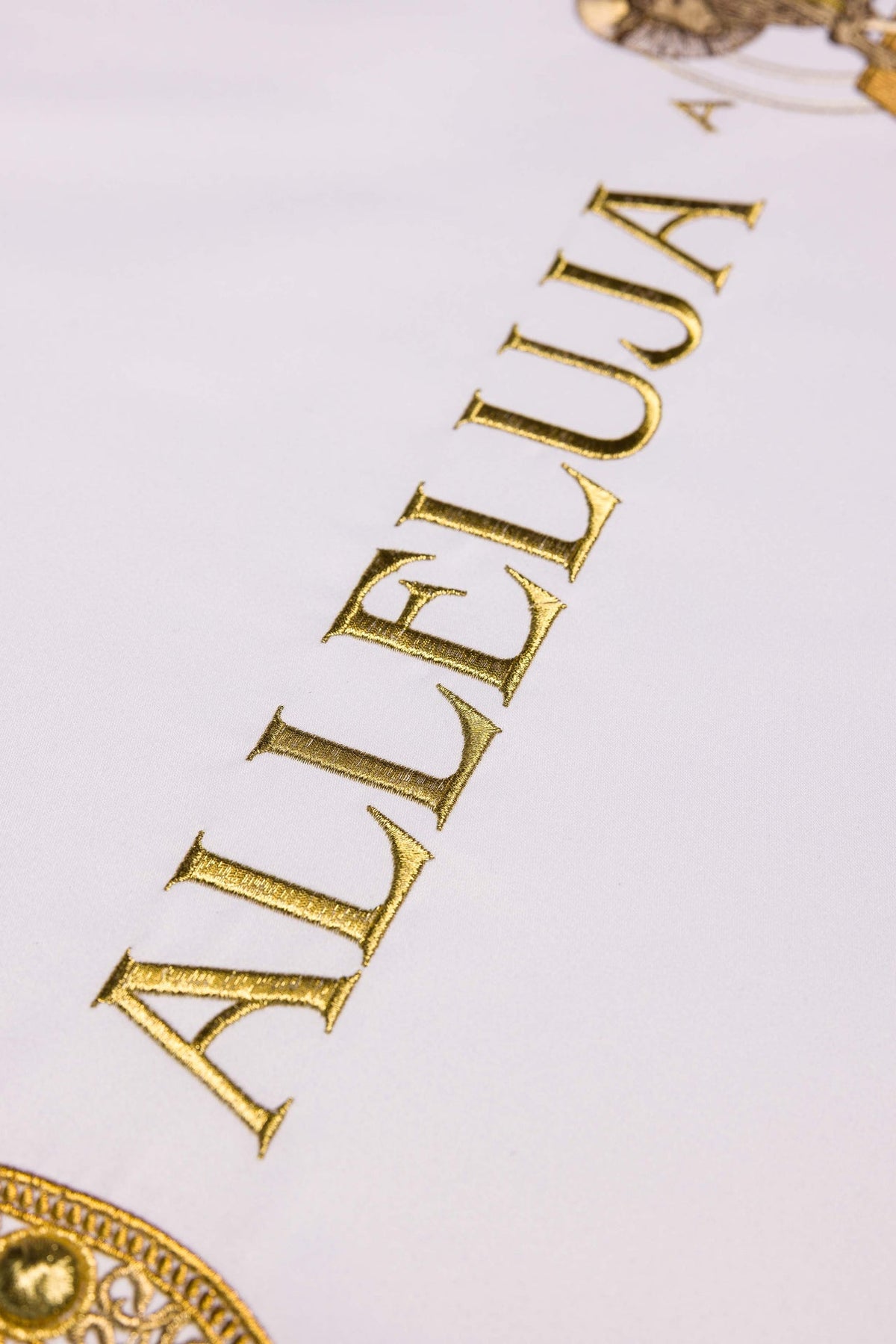Altar cloth close-up showing gold embroidered ALLELUIA lettering