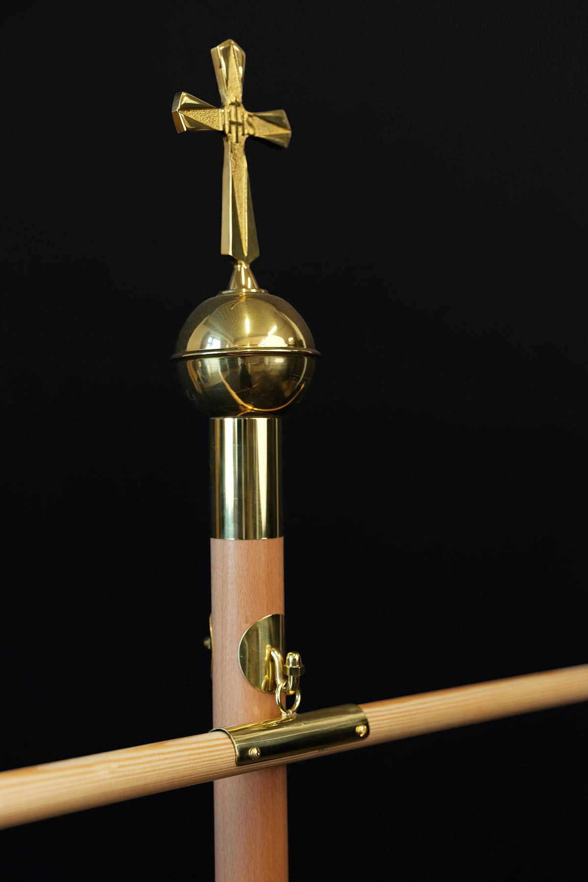 Light wood banner pole with decorative cross, close-up of gold cross and ball finial