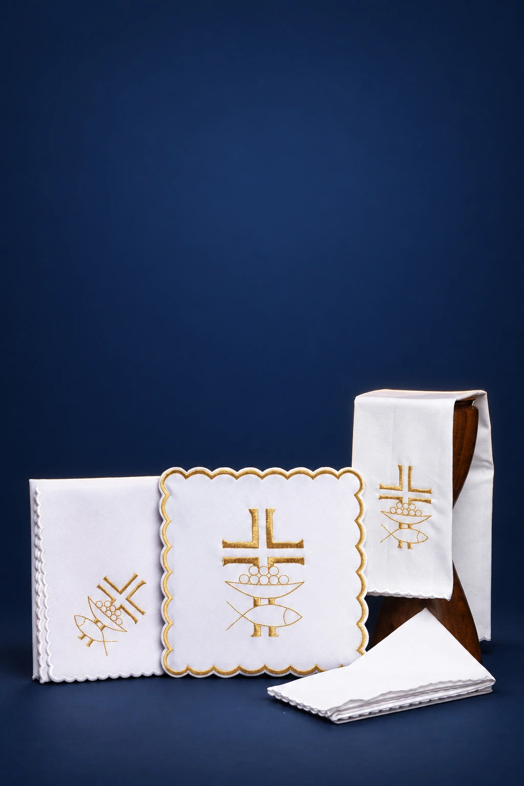 White altar linen set with gold cross and fish embroidery, shown folded in a front view