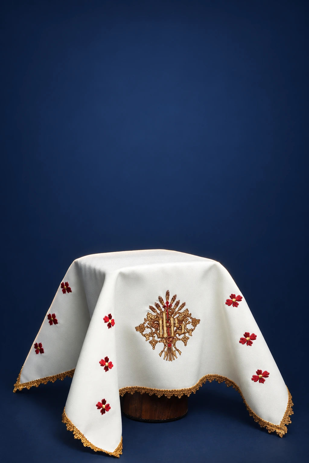 White chalice veil with gold trim, embroidered IHS motif, and red floral crosses