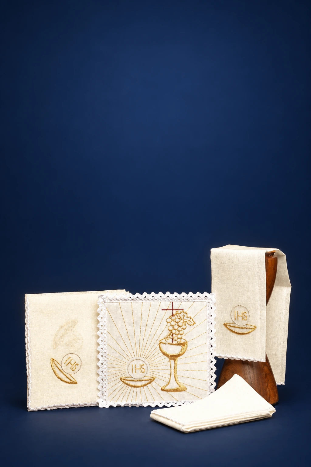 Altar linen set with embroidered chalice and IHS symbols, shown folded with three cloths and purificator