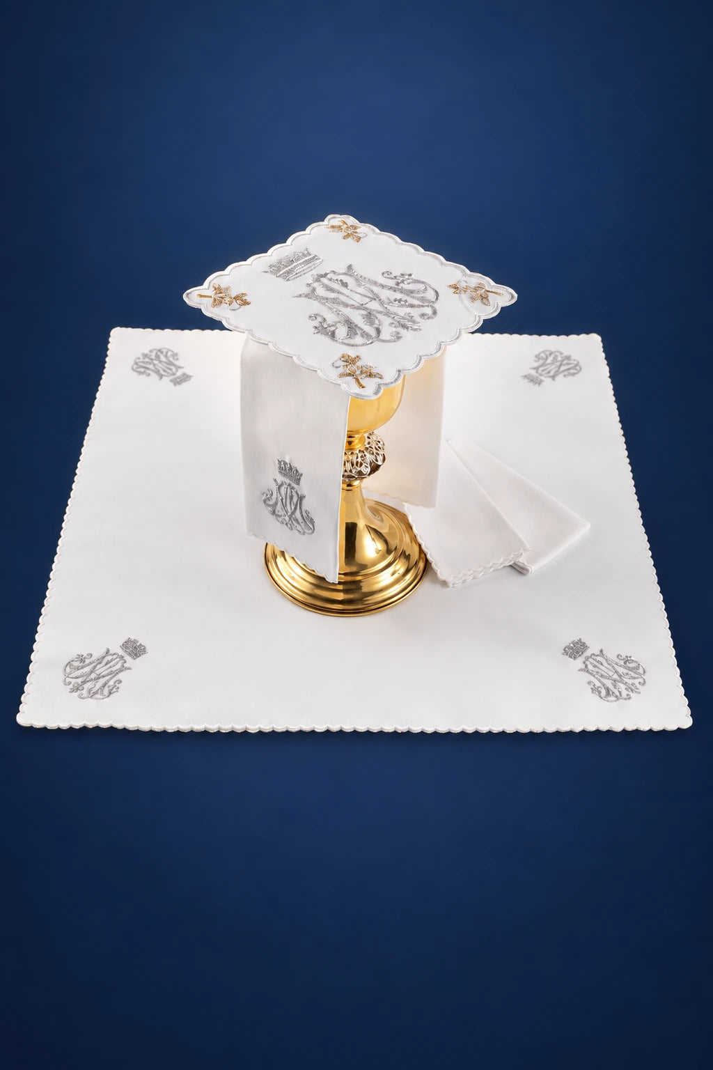 Altar linen set with embroidered Marian motif, shown laid out with a square pall, corporal, and purificator
