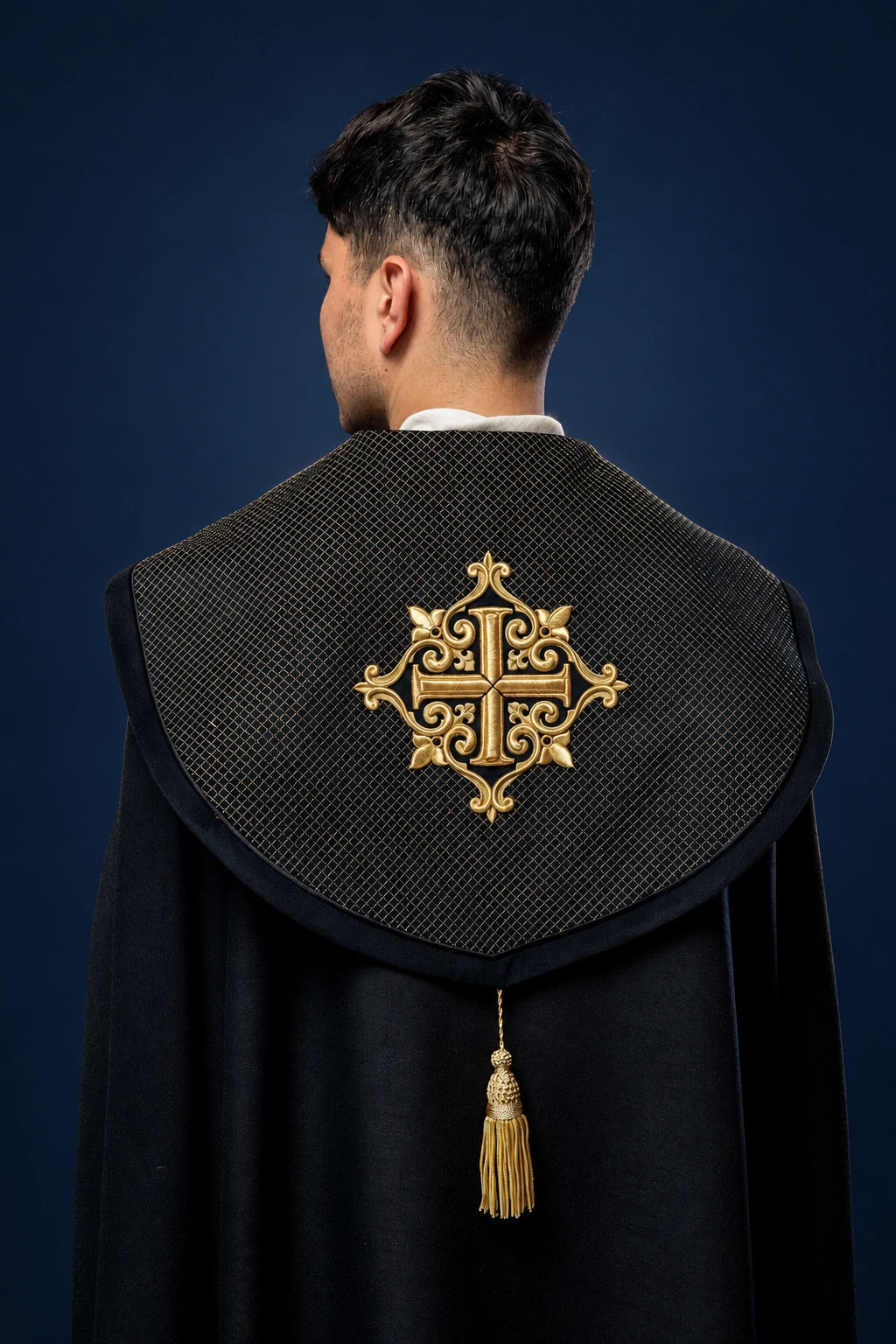 Back view of black cope with velvet orphrey and gold embroidered cross on the hood