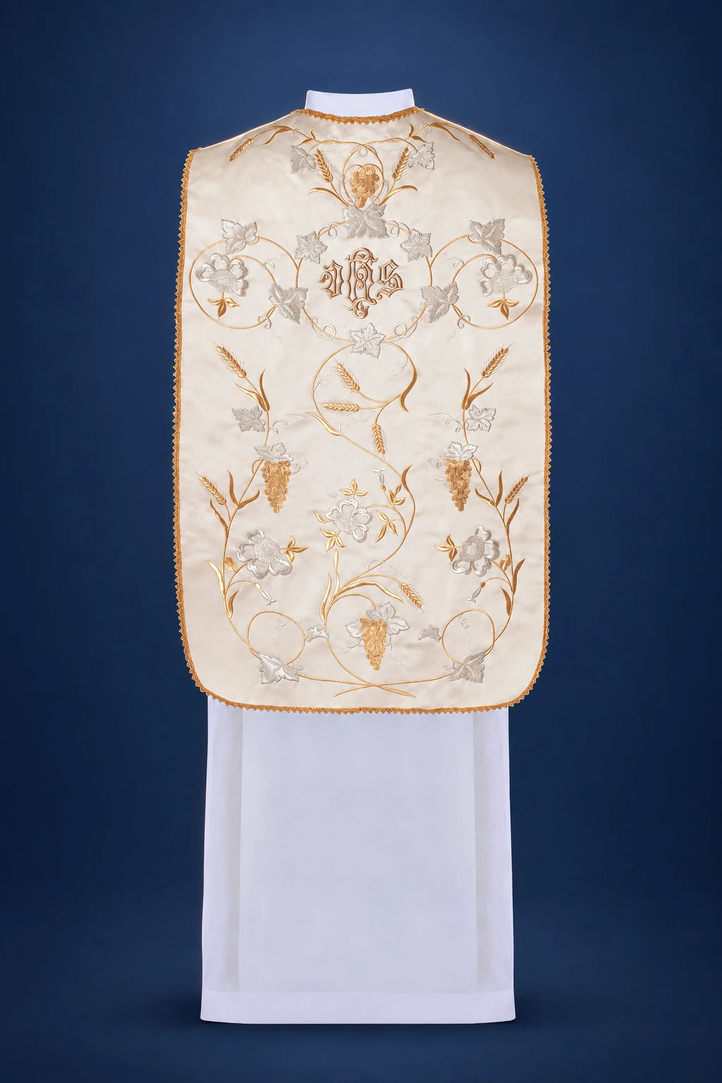 Back view of a cream chasuble with central IHS and wheat-and-grape embroidery, framed by gold trim