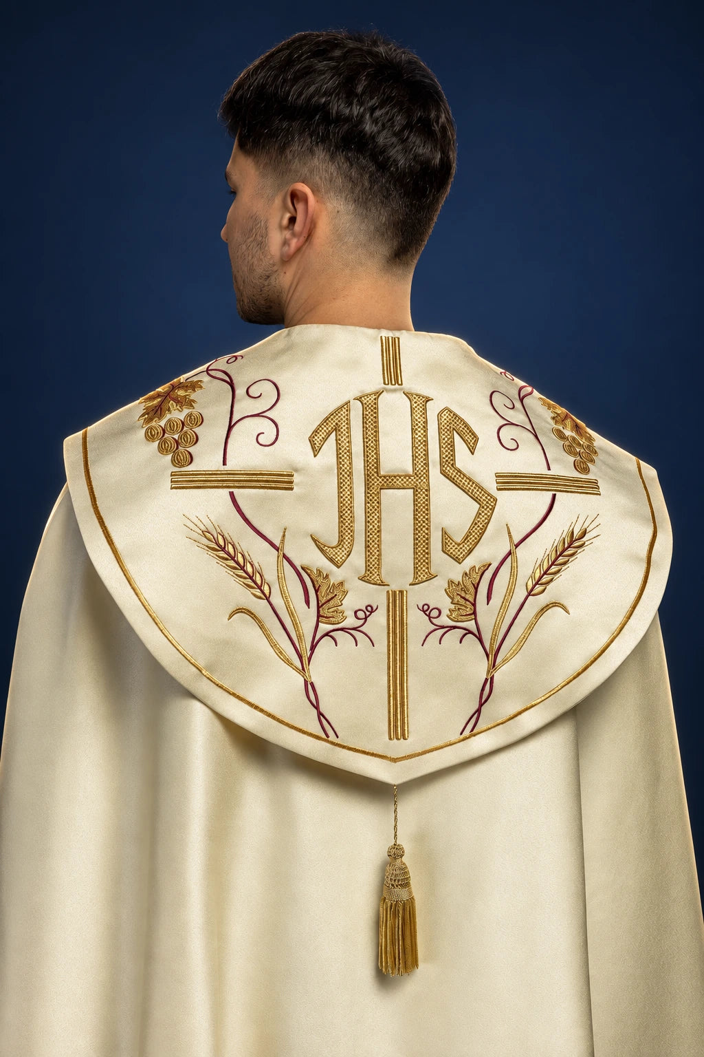 Back view of an ecru cope with embroidered IHS, cross, wheat, and grapes on the hood