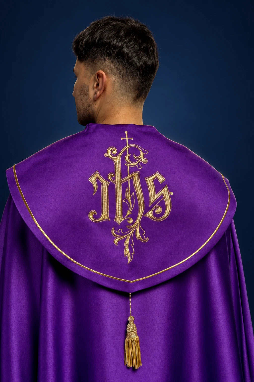 Back view of a purple cope with gold trim and large gold IHS monogram on the capelet, tassel cord below