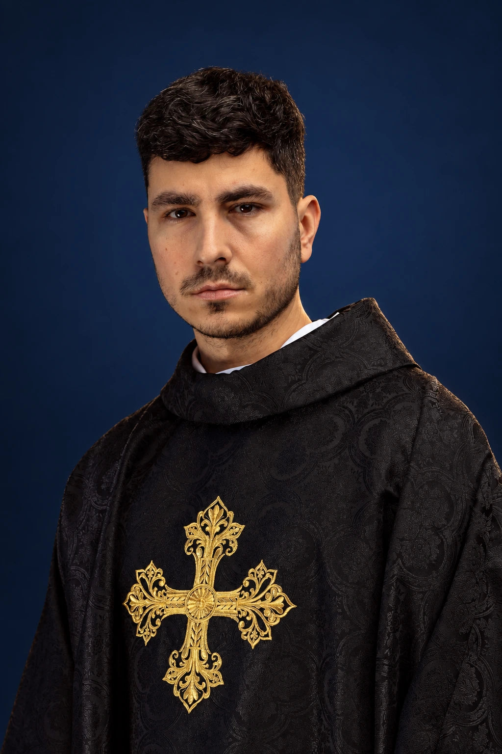 Black chasuble front view with a large gold cross on jacquard fabric