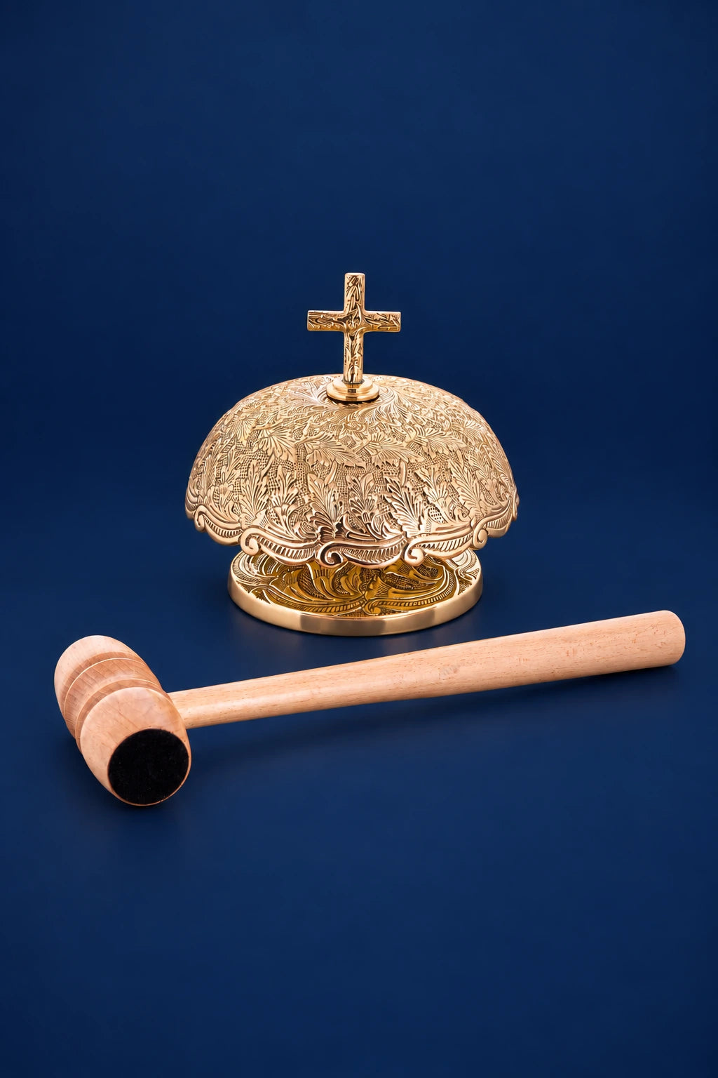 Brass altar bells with cross finial and wooden mallet, front view