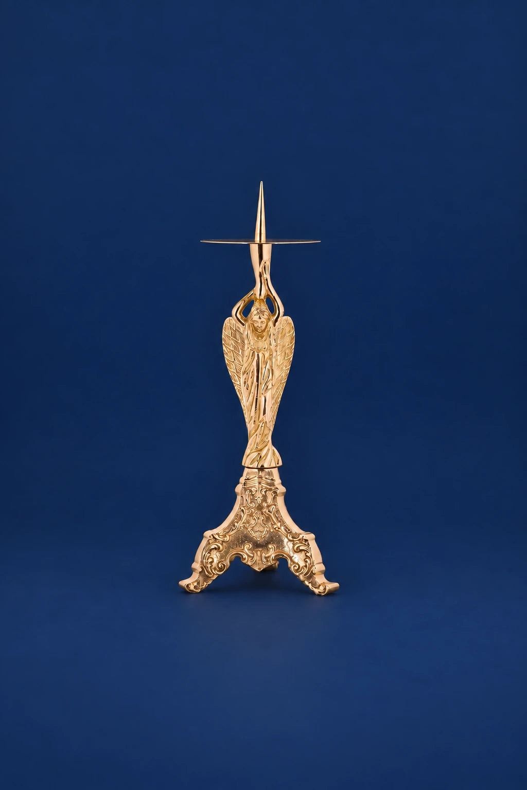 Brass candlestick with angel figure and ornate three-legged base, front view