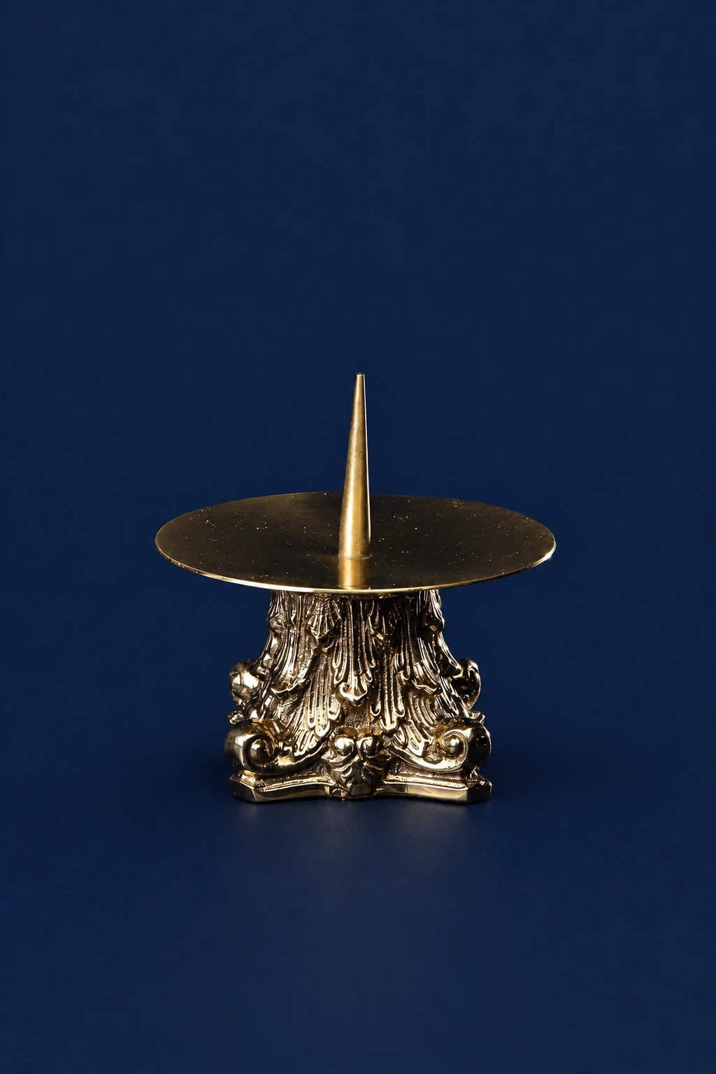 Brass candlestick with ornate base and slender spike, front view