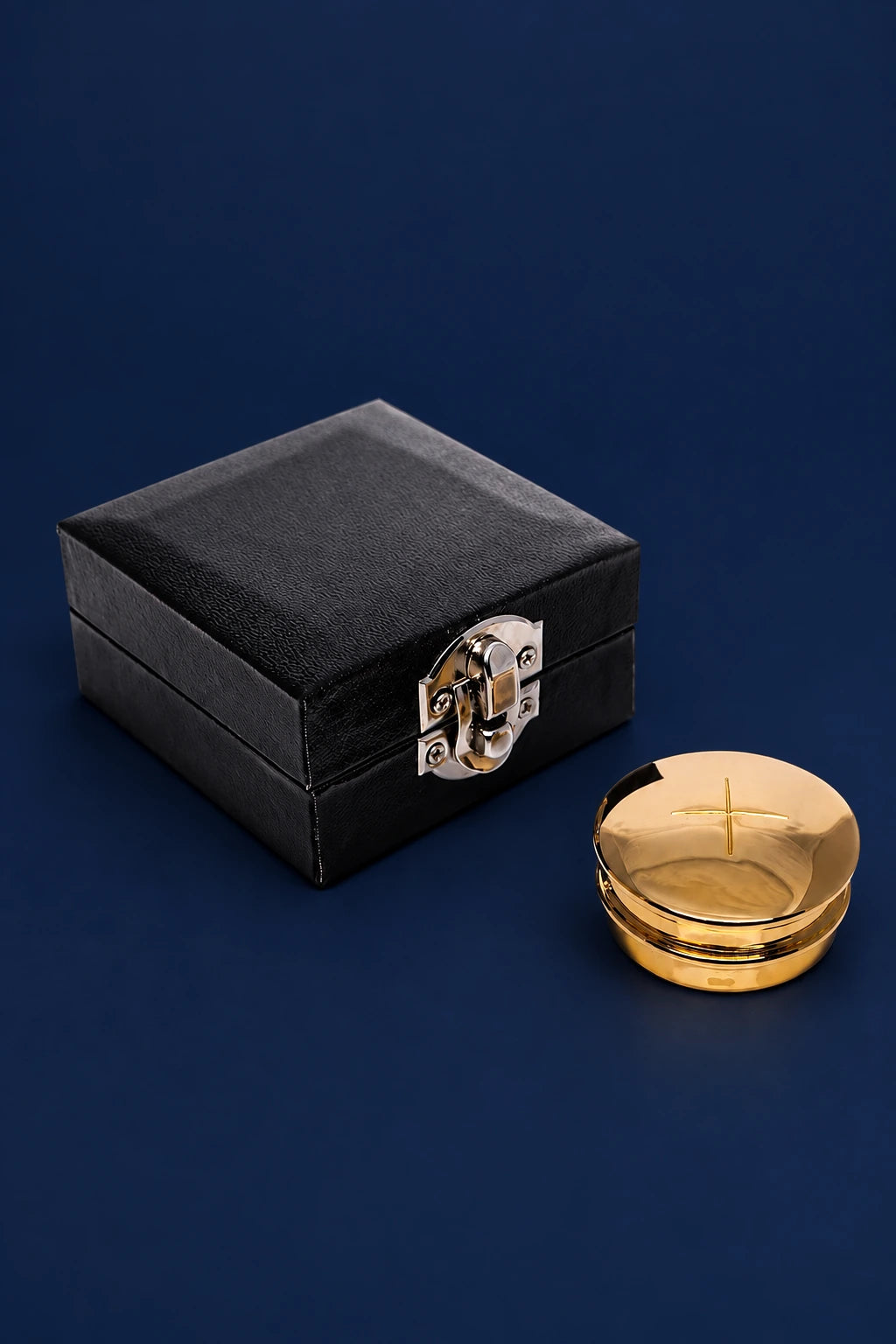 Brass pyx with black case, shown closed with the pyx beside it