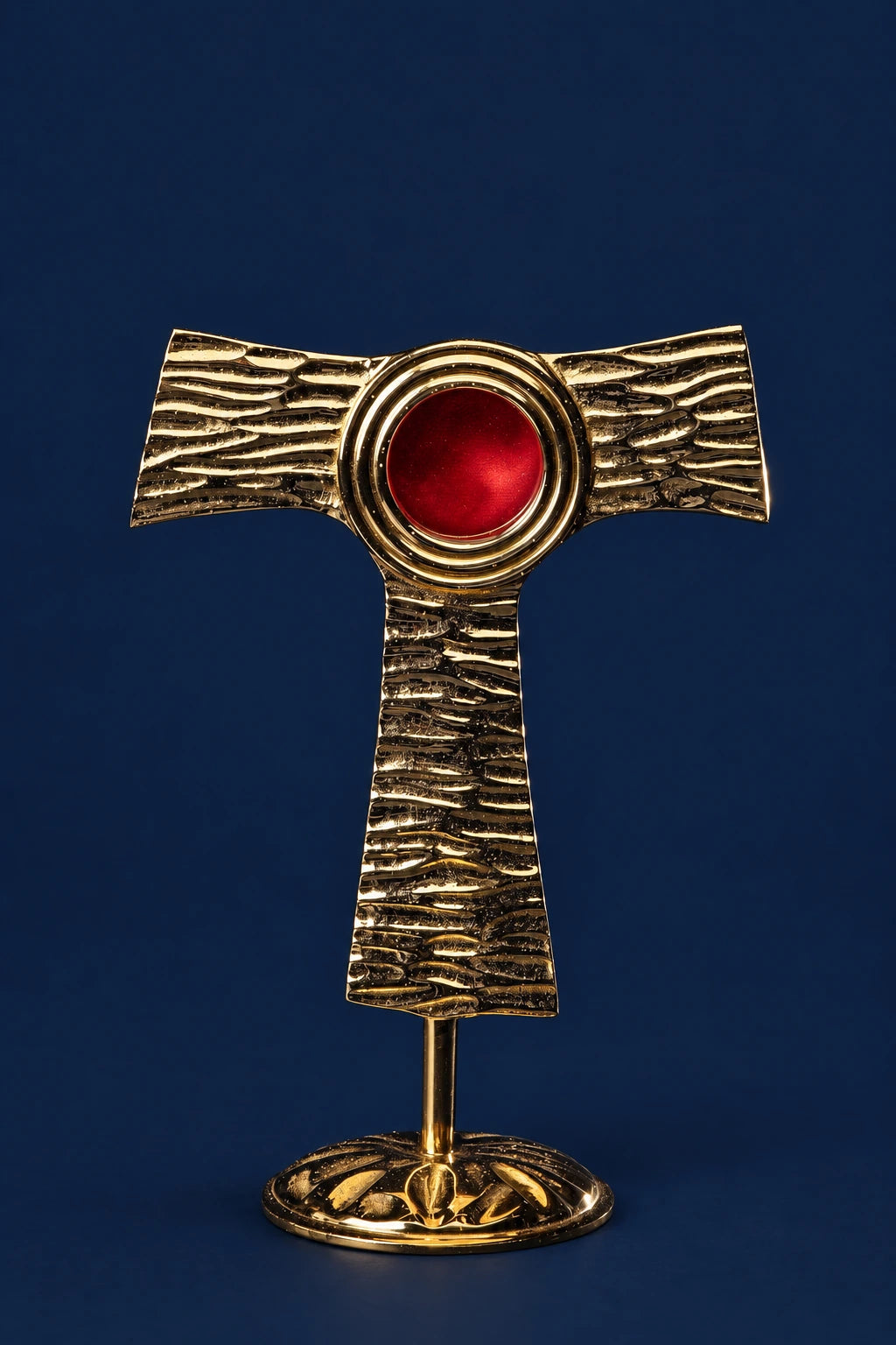 Brass tau cross reliquary on a stand with a red round center repository