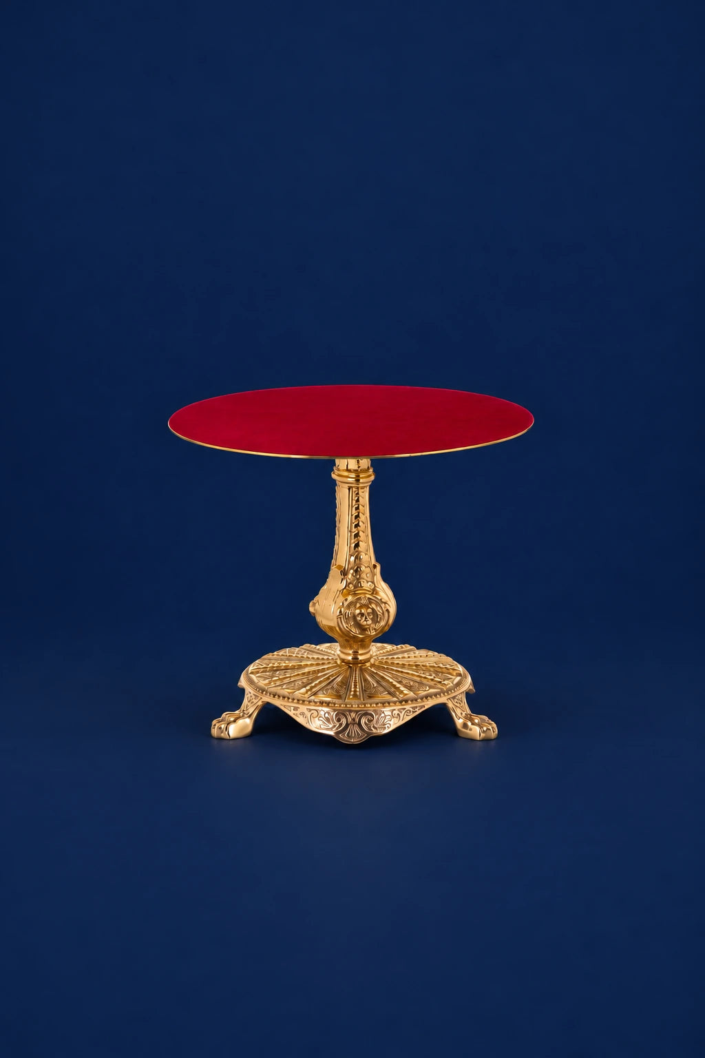 Brass thabor table with red velvet top and ornate pedestal base, front view