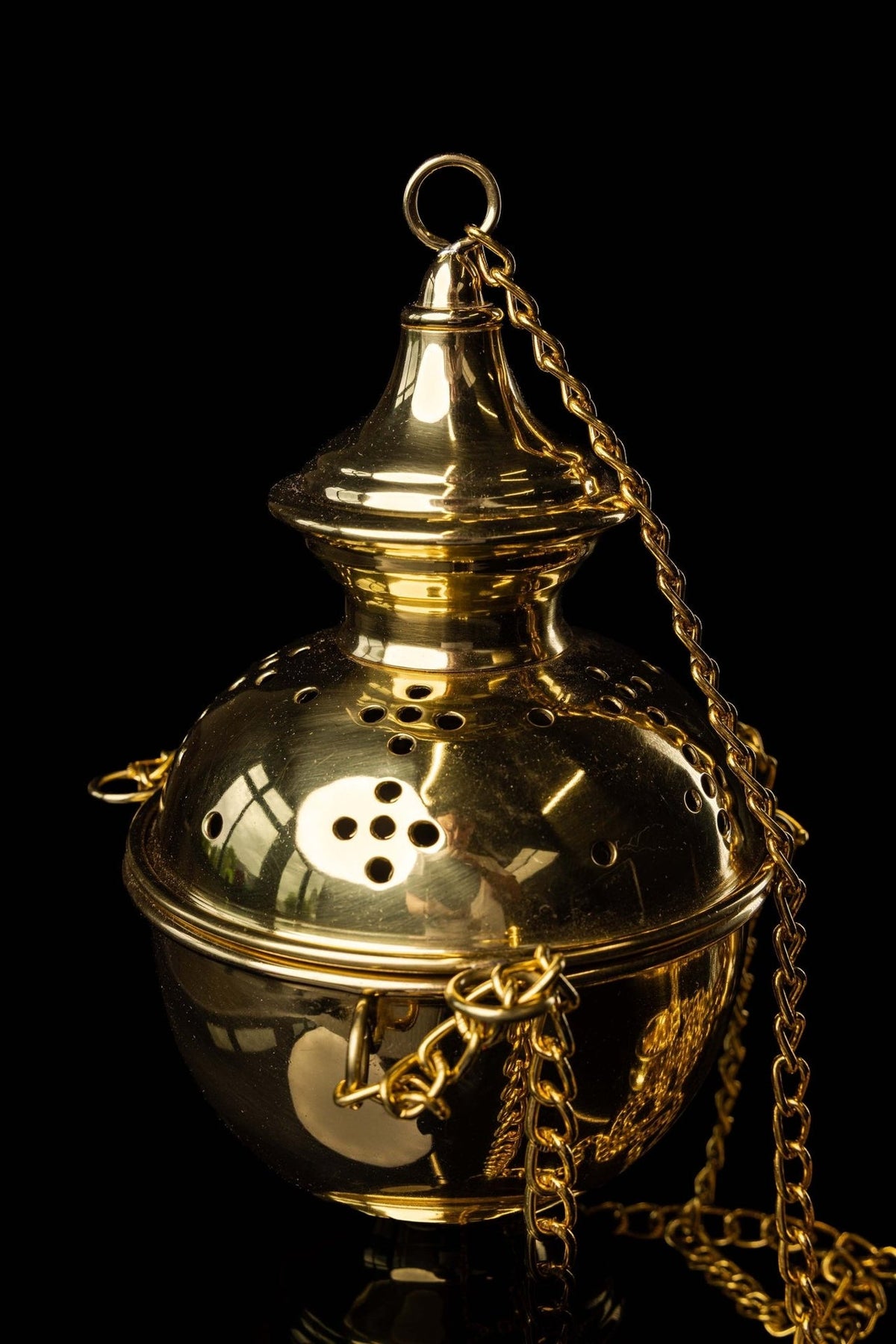 Brass church thurible close-up showing its gold lid, ring and chains