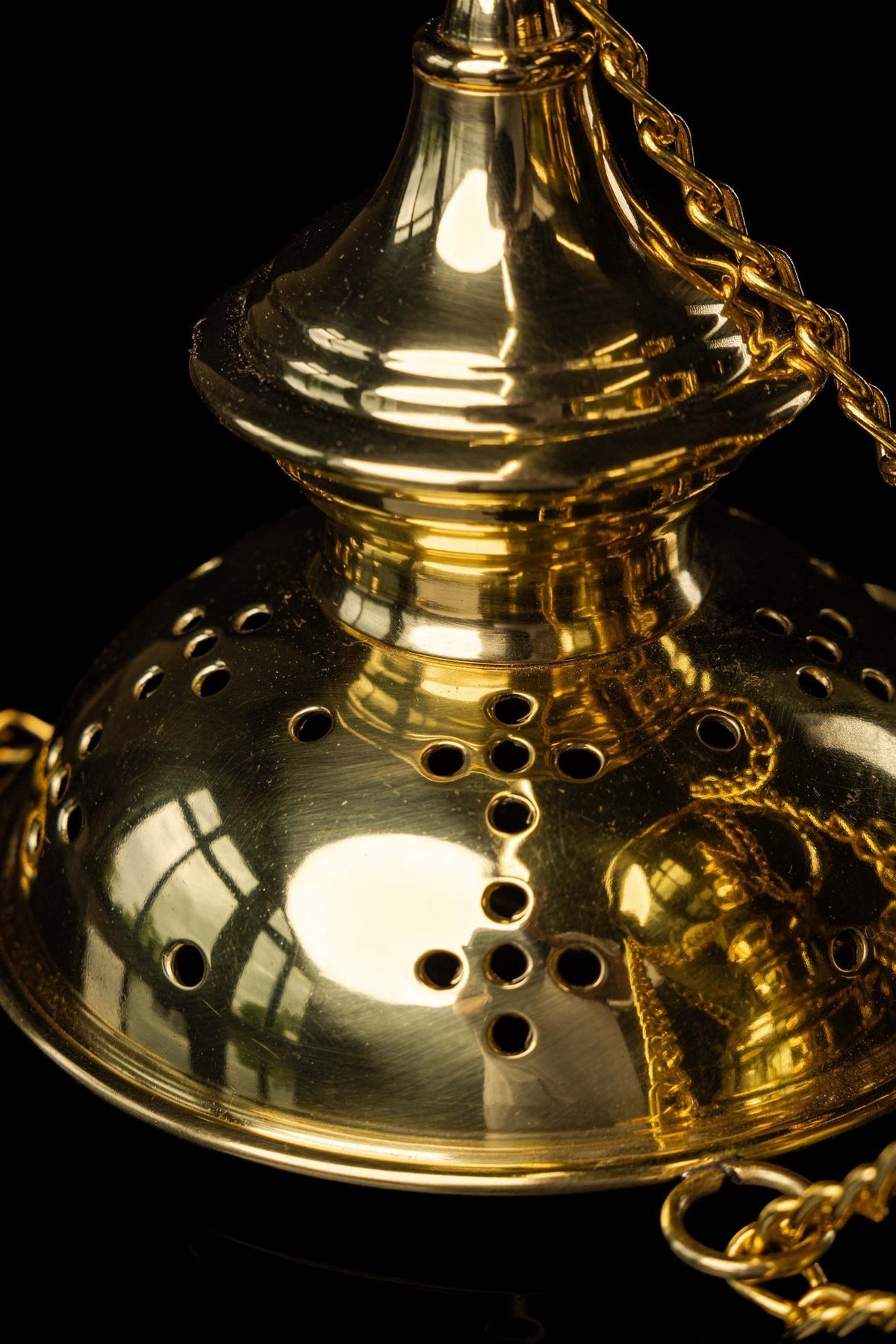Gold church thurible bowl close-up showing decorative perforations