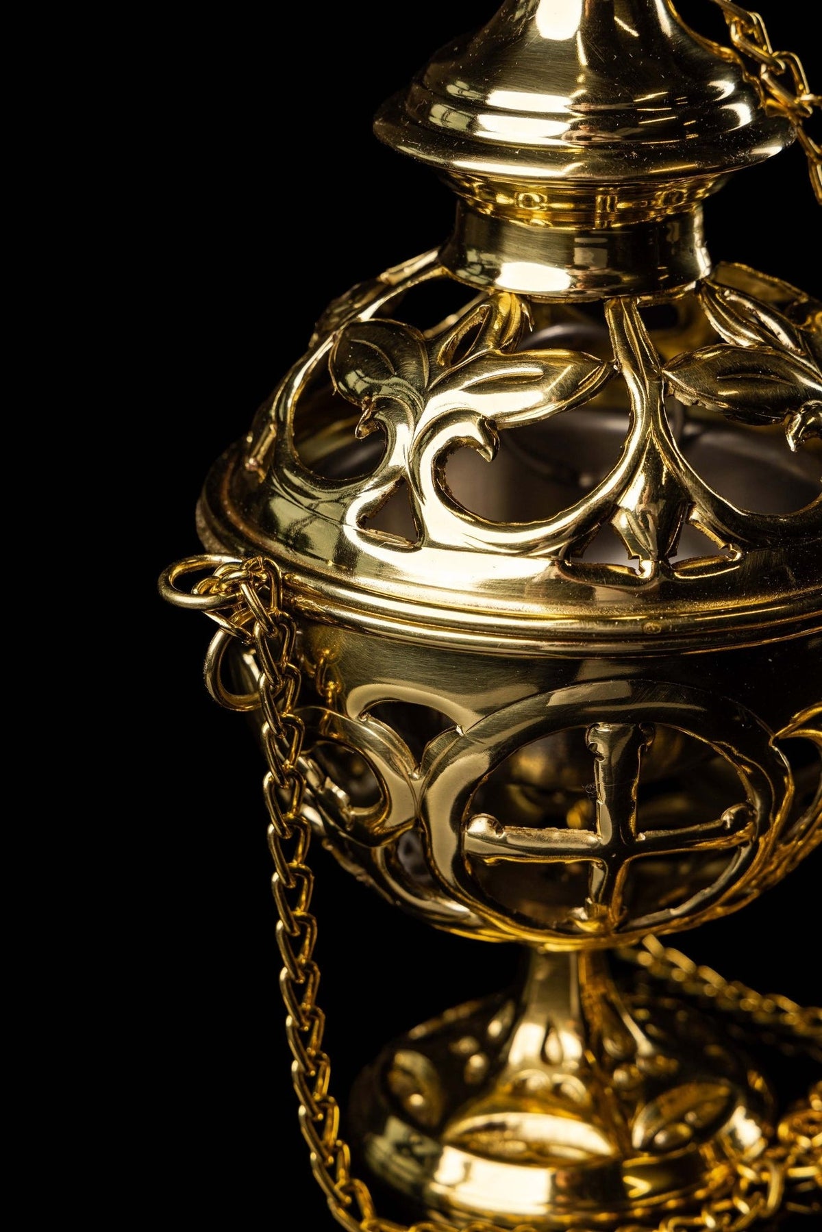 Brass thurible close-up showing decorative openwork lid and cross motif