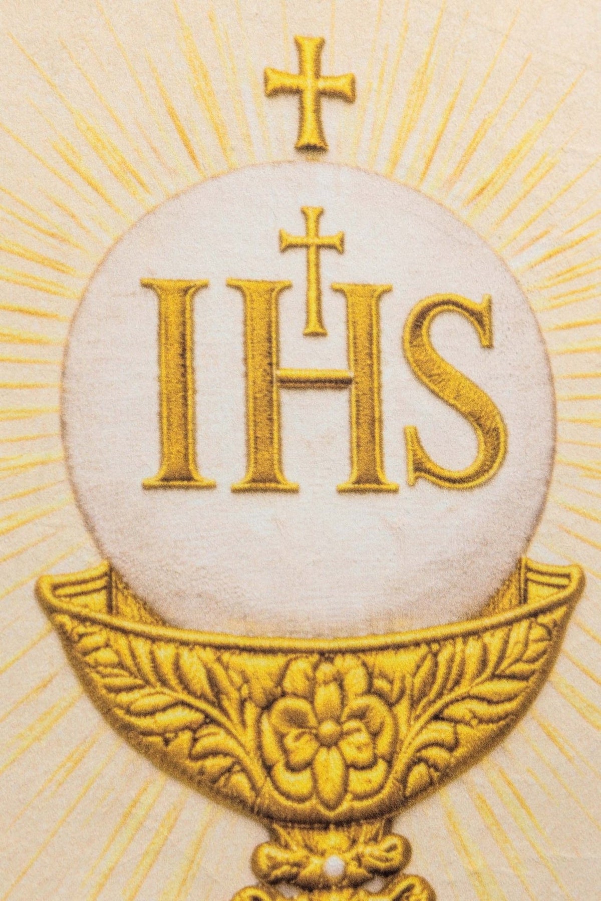 Church banner close-up of gold IHS and chalice design on white fabric