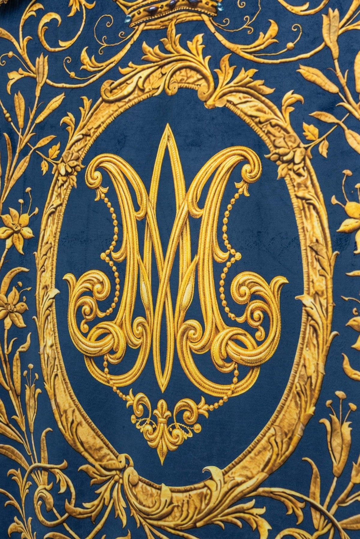 Double-sided printed church banner with Marian monogram, blue and gold close-up