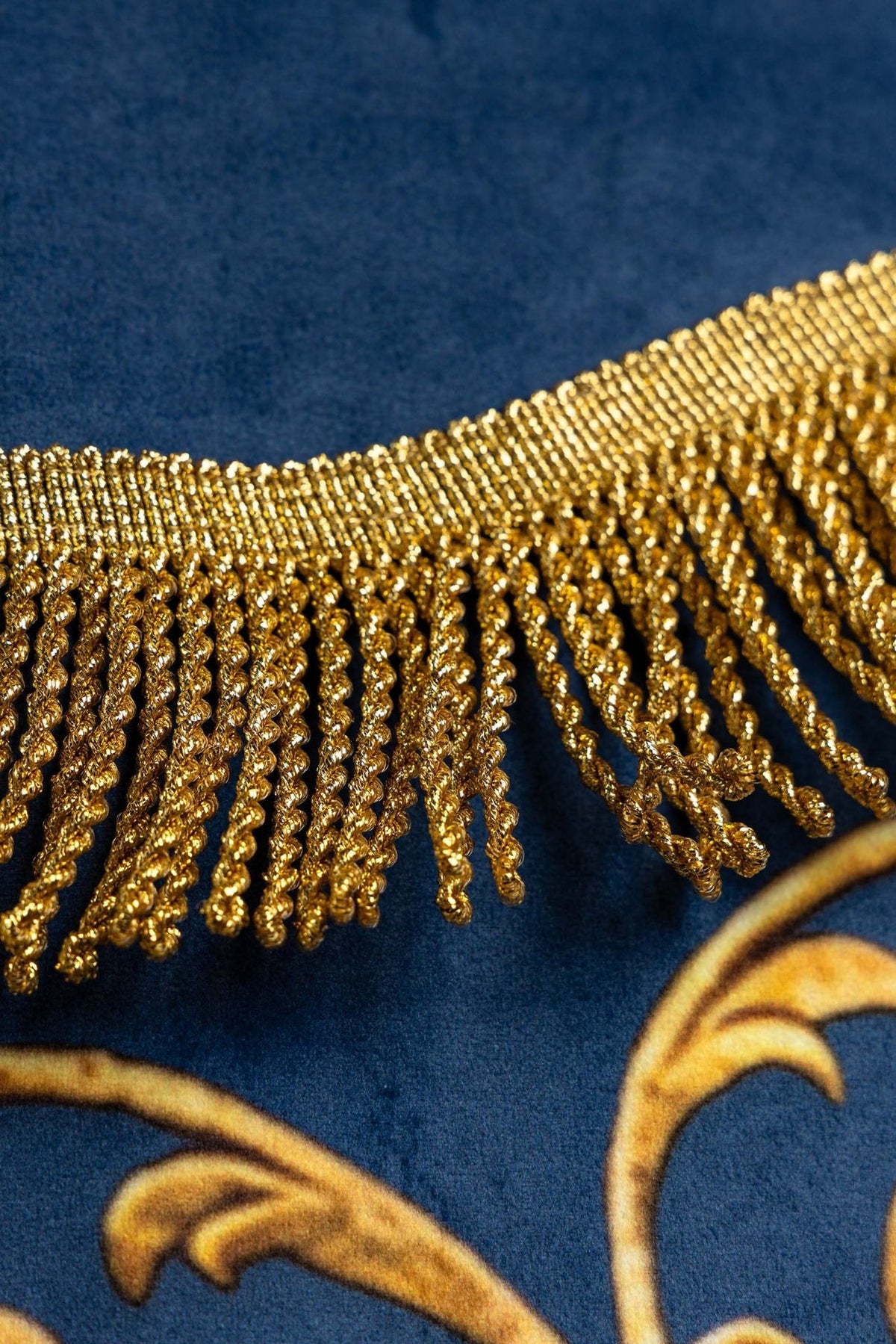 Church banner detail of blue fabric, gold fringe and top finial