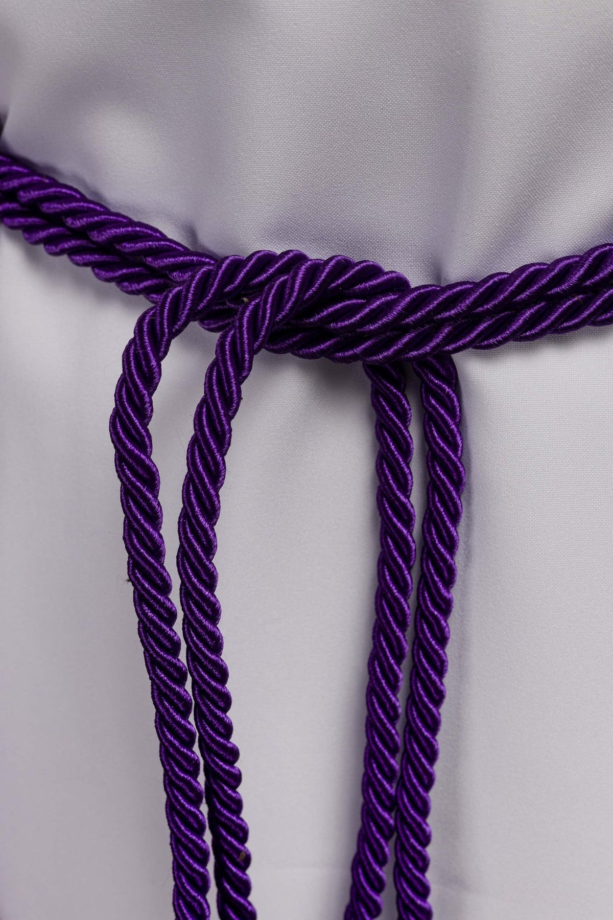 Purple cincture close-up showing braided cords and central knot