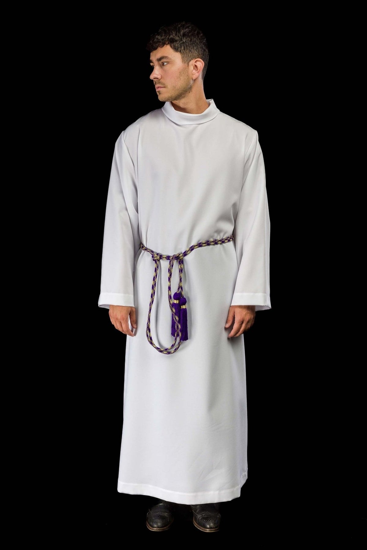 Purple and gold cincture worn around the waist of a white alb