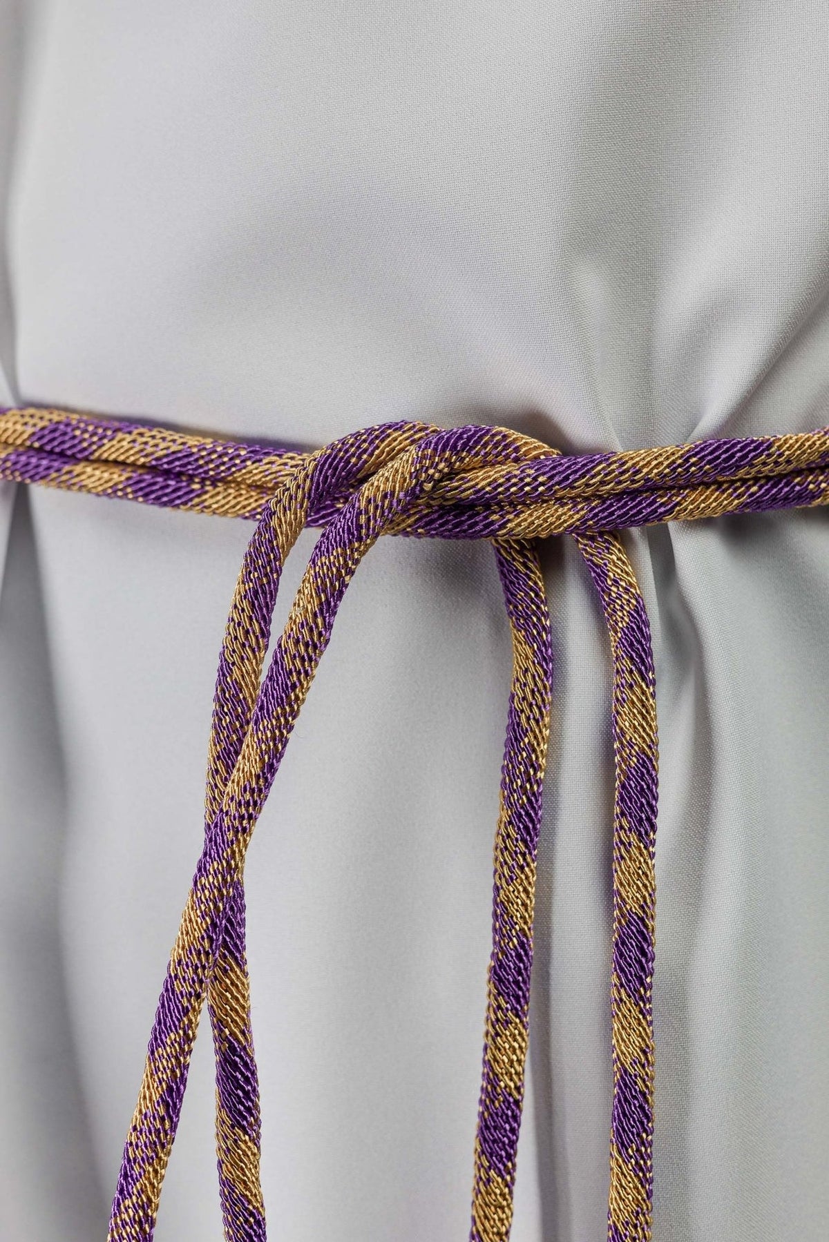 Purple and gold cincture close-up showing the braided cord and hanging loops