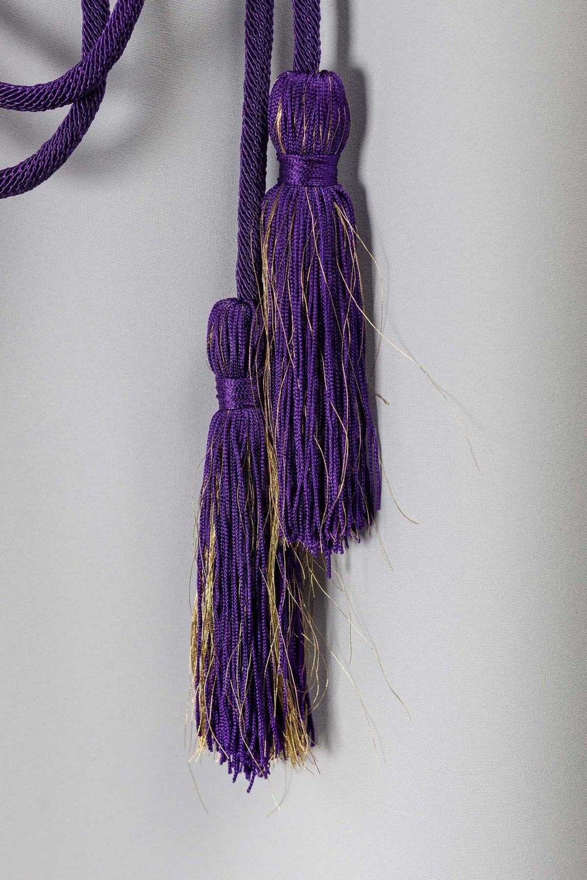Purple cincture close-up showing decorative purple and gold tassel ends