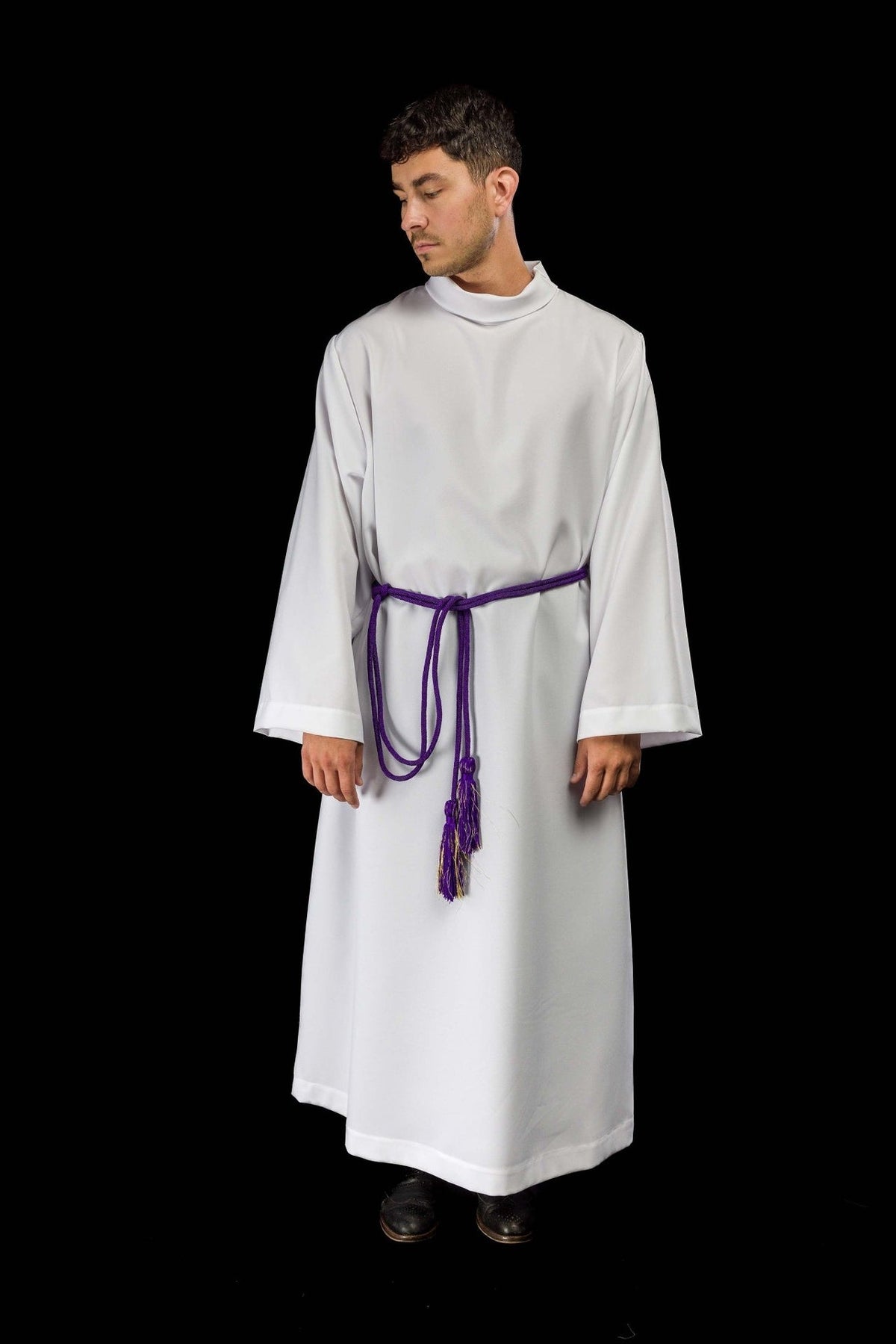 Purple cincture worn around an alb, with hanging decorative tassel ends