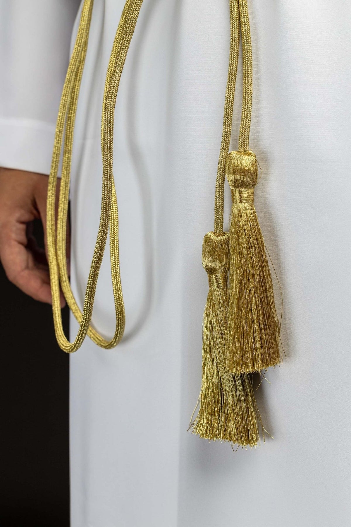 Gold cincture side detail with braided cord and hanging tassels
