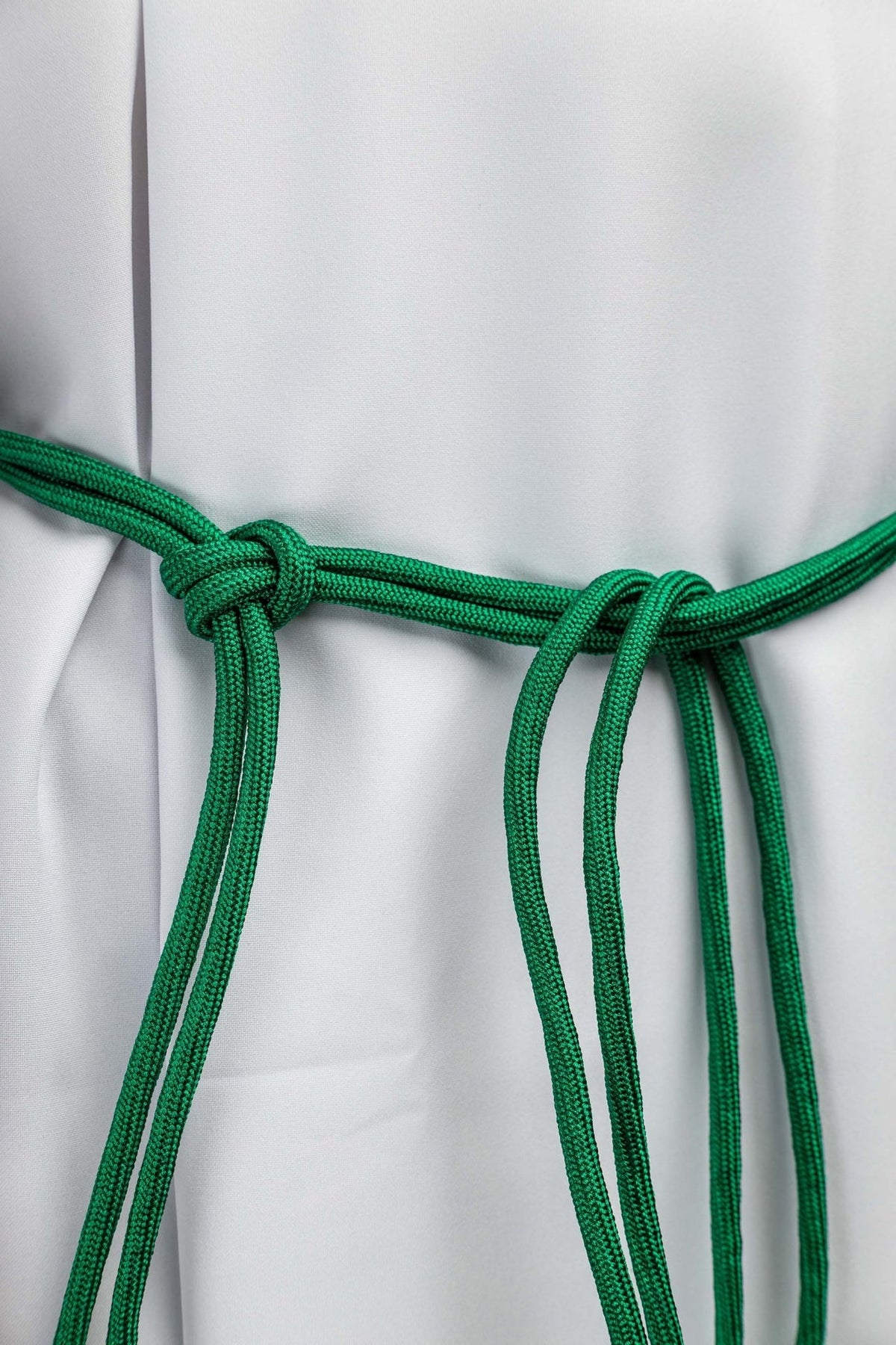 Green cincture close-up showing braided cord and waist knot