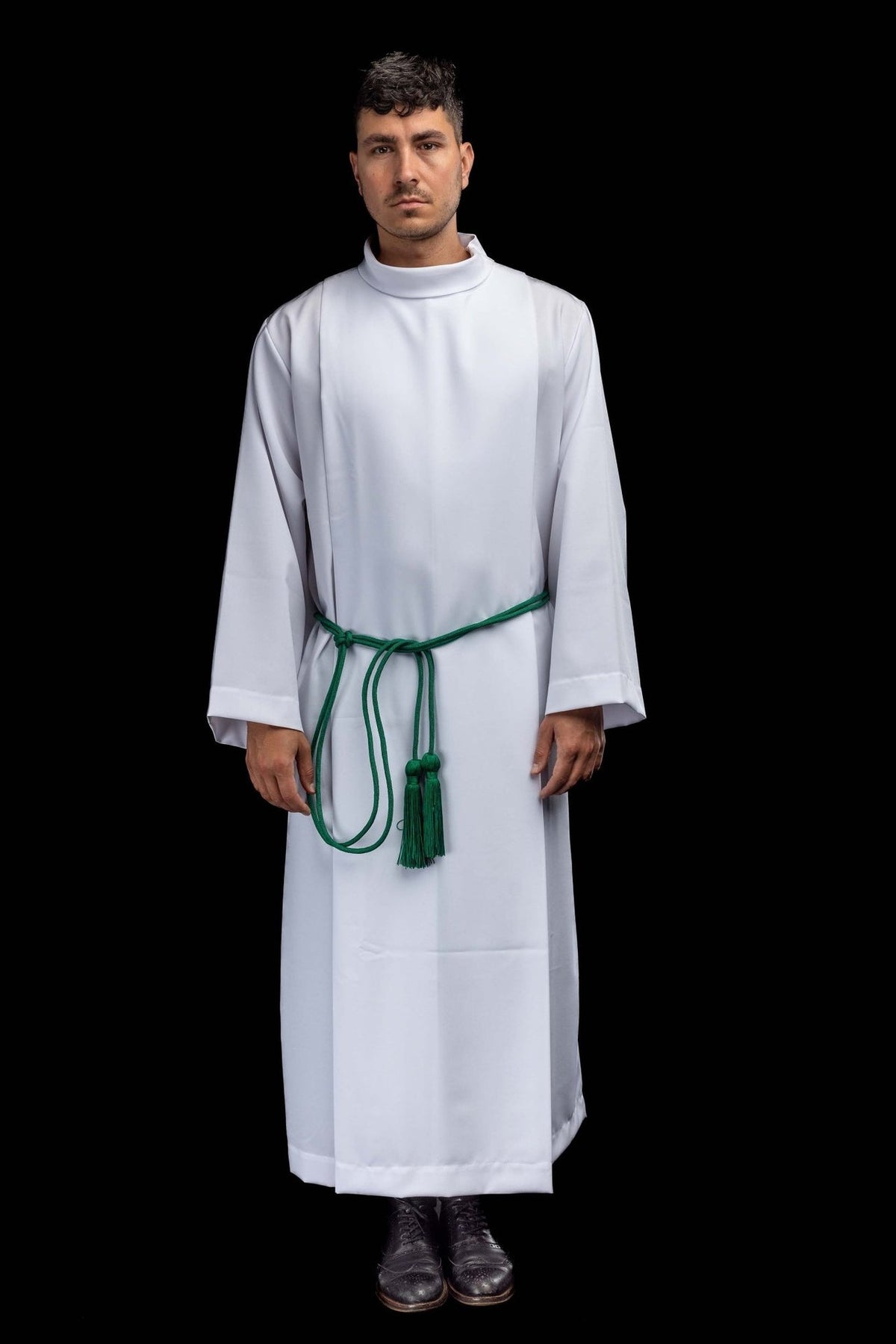 Green cincture worn around a white alb, with tassels hanging at the front