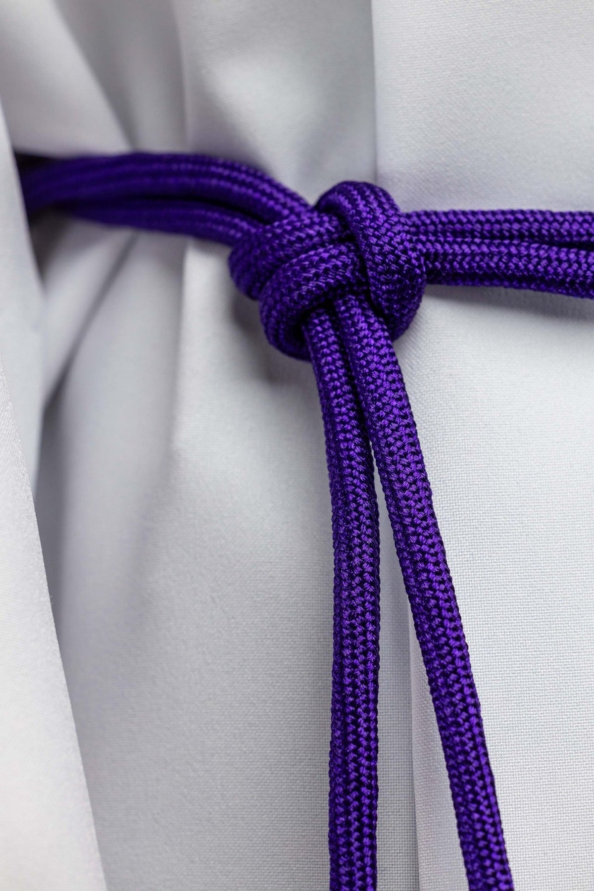 Purple cincture close-up showing the braided cord and tied knot