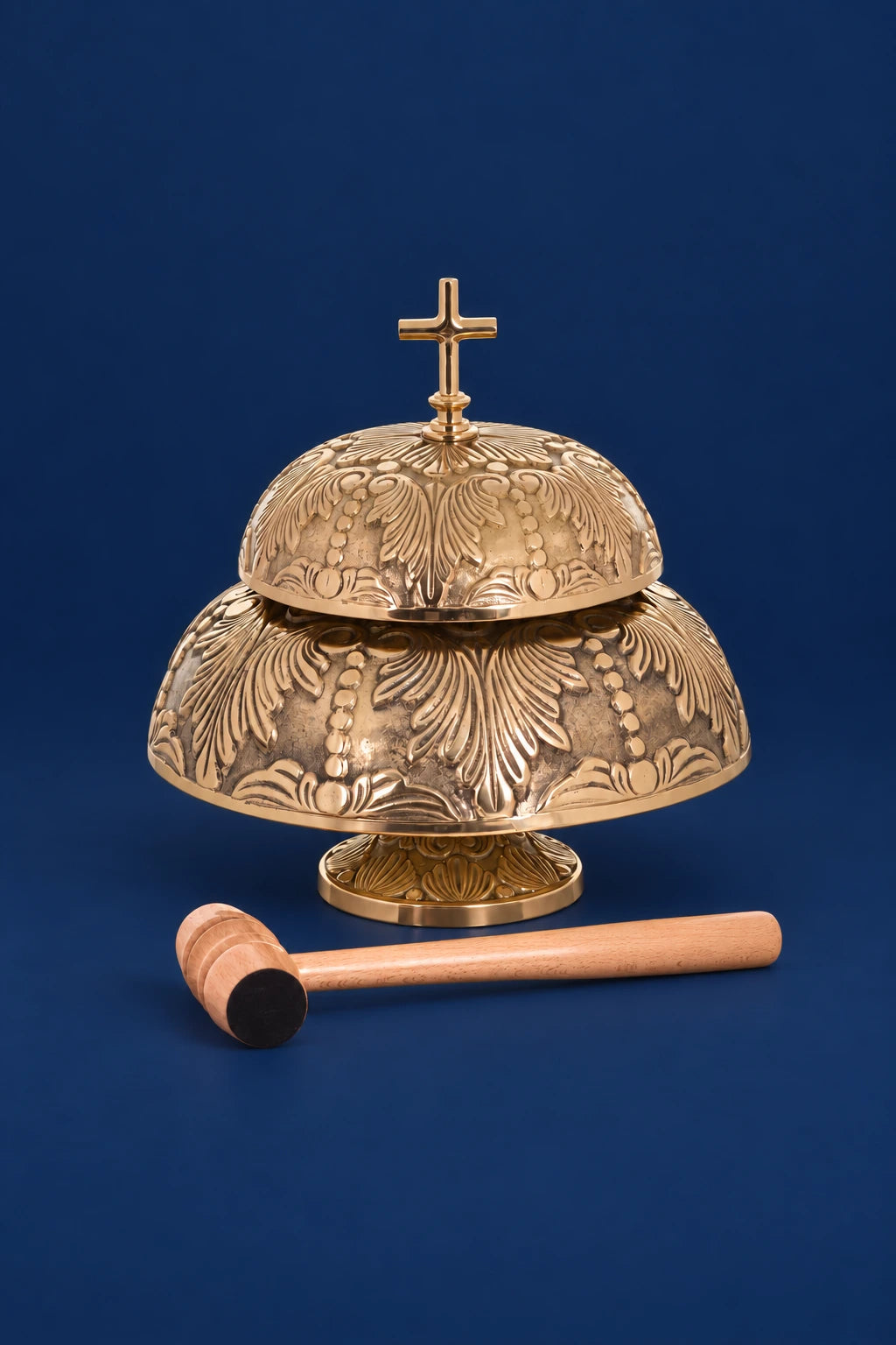 Decorated two-tone altar bells with cross finial and wooden mallet, front view
