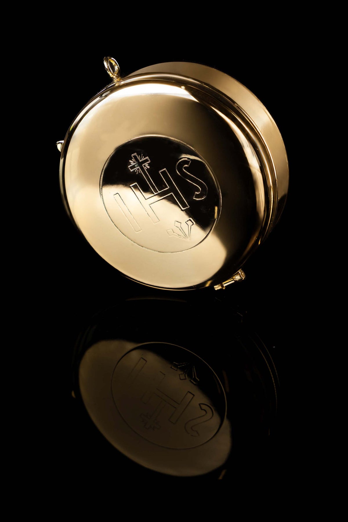 Gold-plated ciborium viewed from below, showing the engraved IHS lid