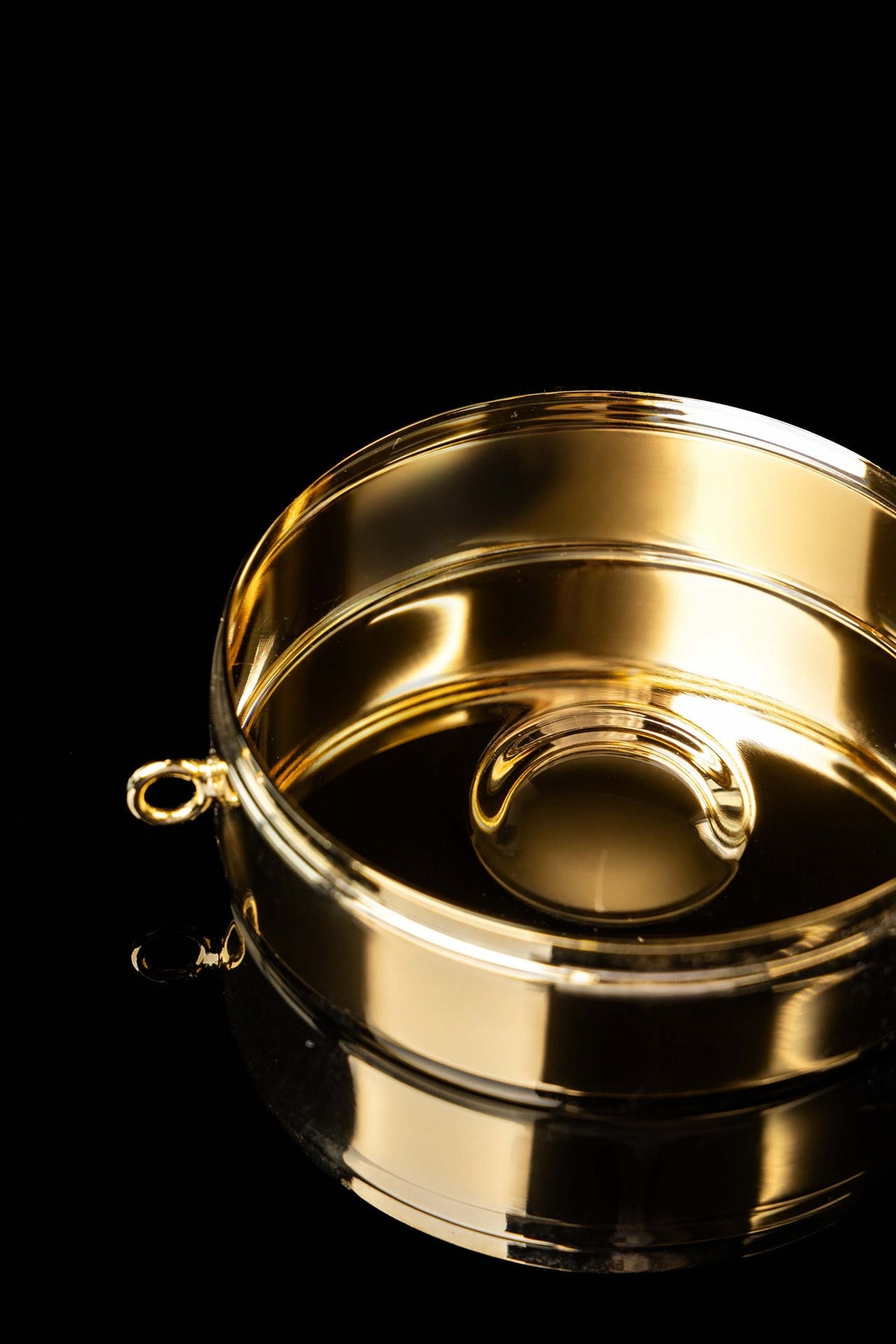 Gold-plated ciborium open, showing its polished interior and raised center