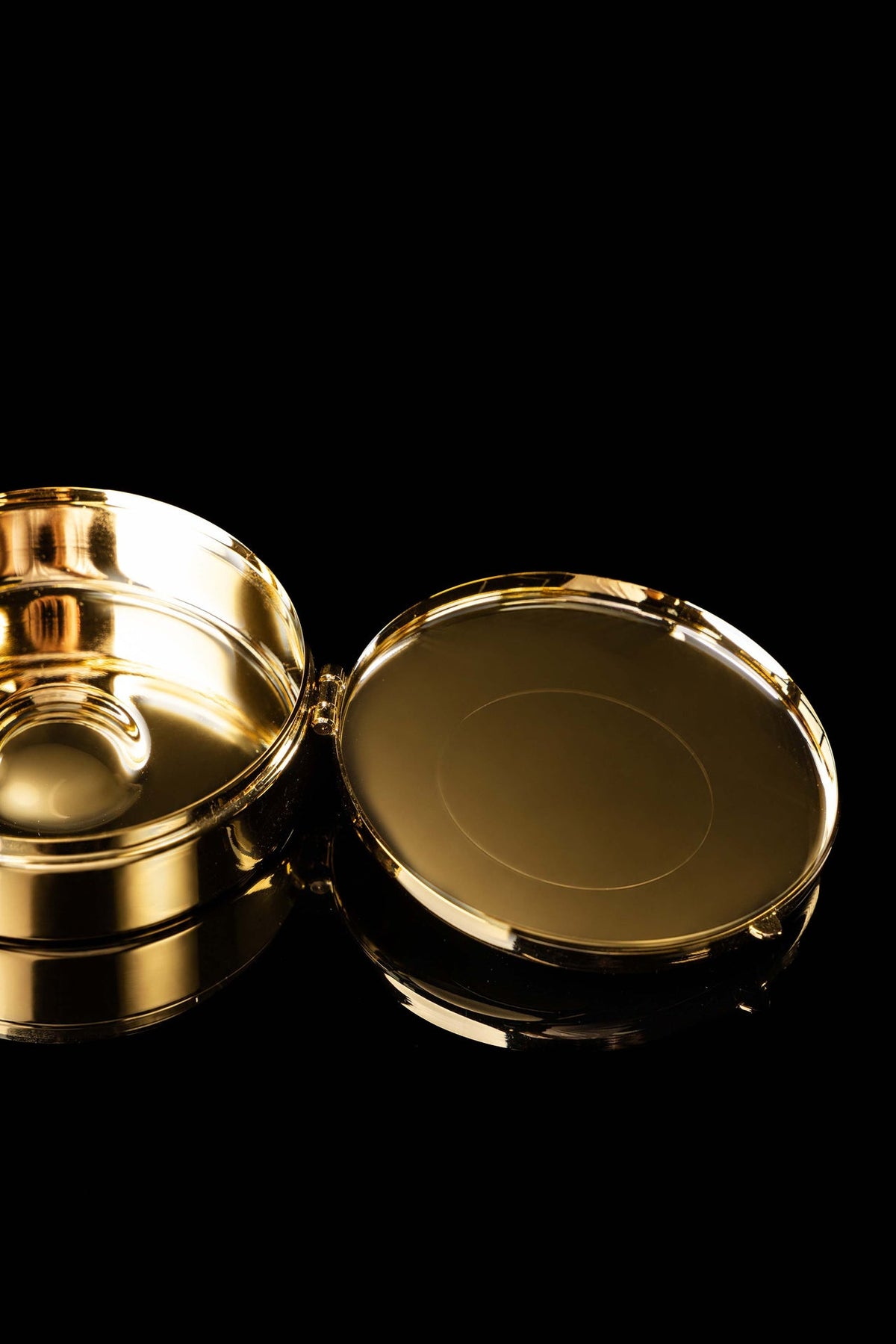 Gold-plated ciborium open with IHS lid and polished interior visible