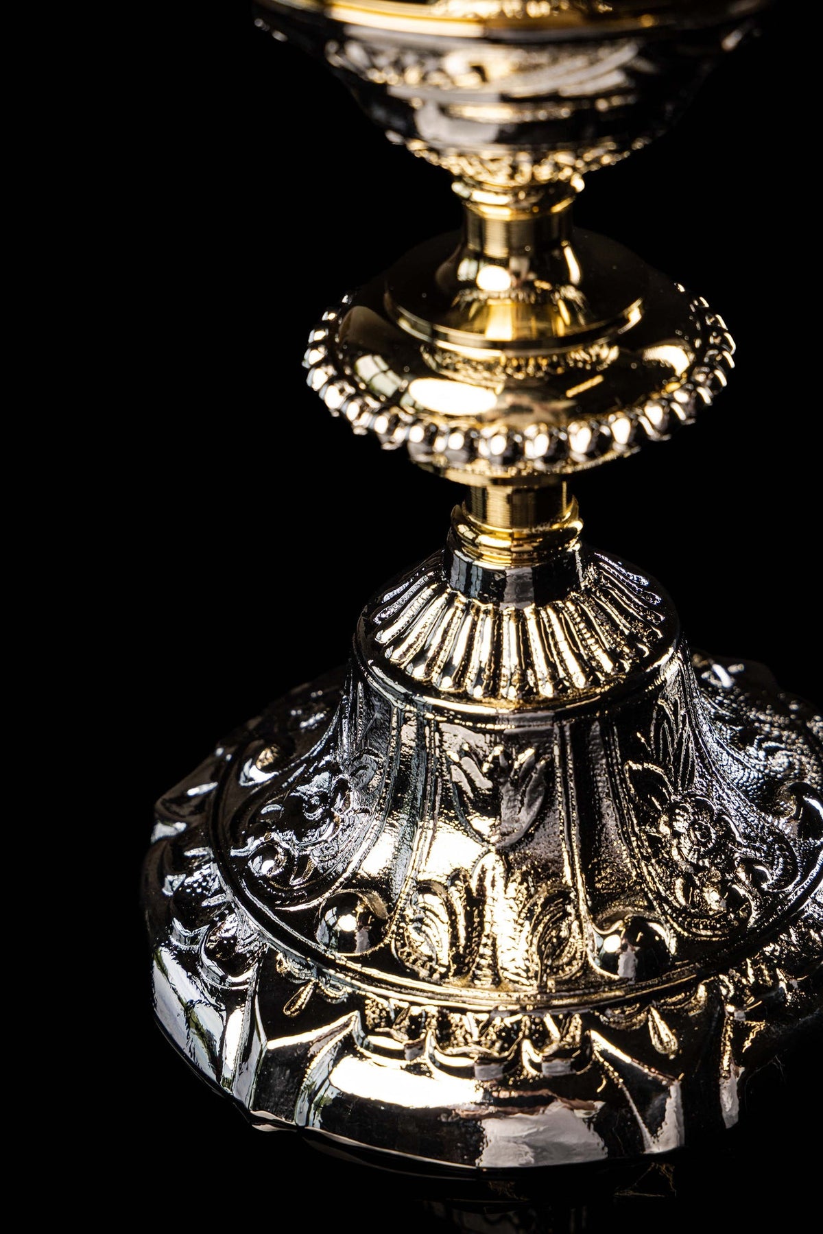 Gold and silver chalice close-up showing ornate silver relief and gold accents on the lower base