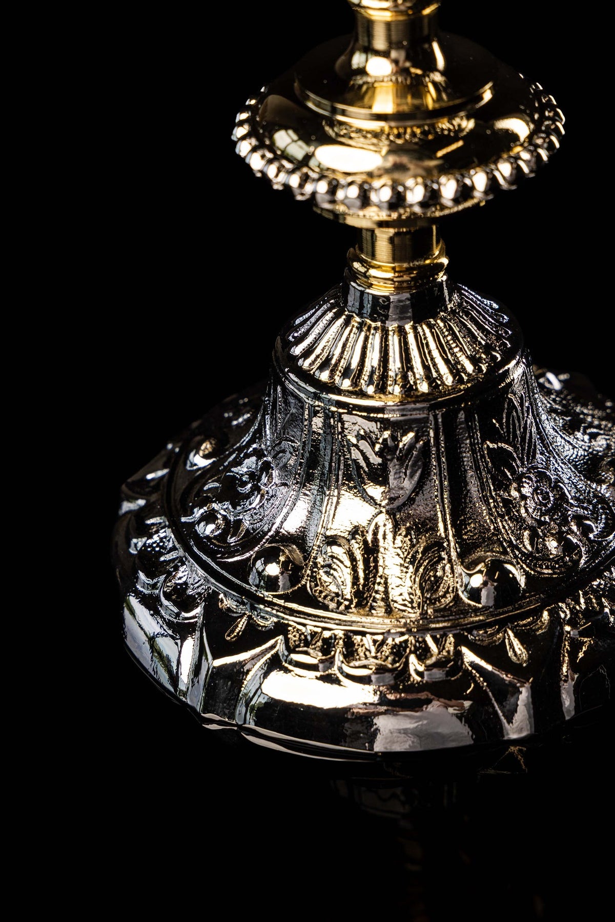 Gold and silver chalice close-up showing the ornate cup band and upper stem