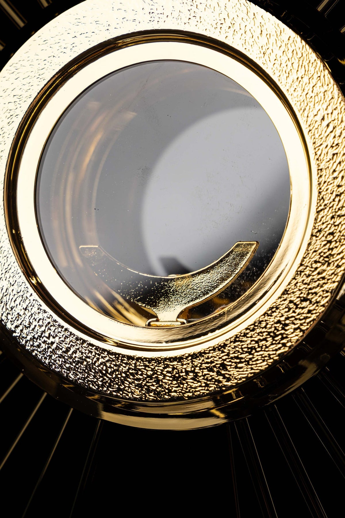 Gold-plated brass monstrance close-up of the textured circular frame and luna