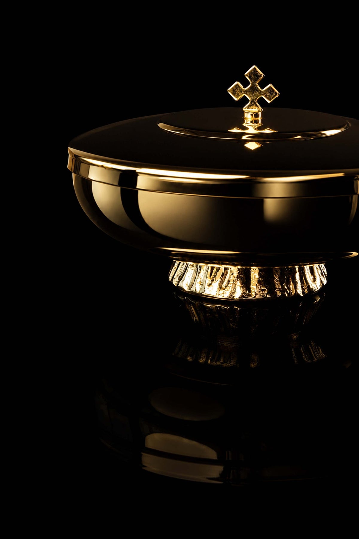 Gold-plated brass ciborium close-up showing the cross finial, rim, and fluted base