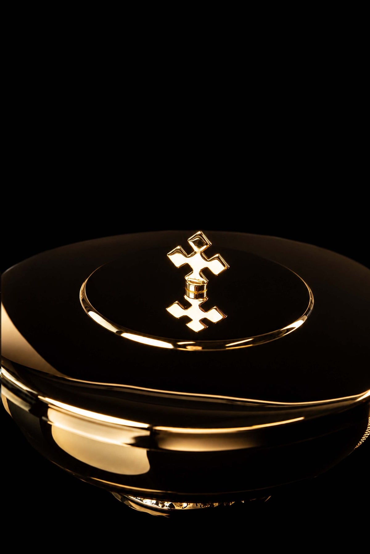 Gold-plated brass ciborium lid close-up with raised cross finial and circular rim