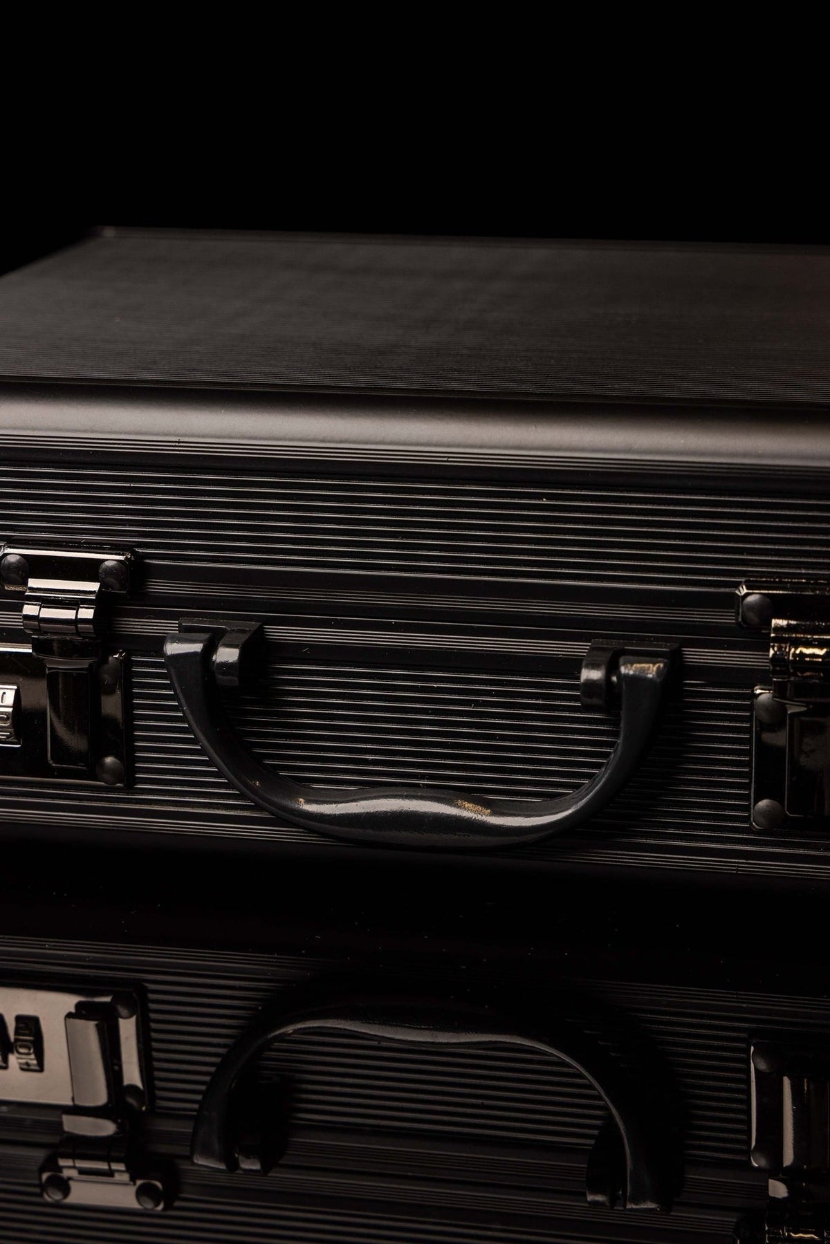 Liturgical equipment case close-up showing black handle, ribbed exterior and latches