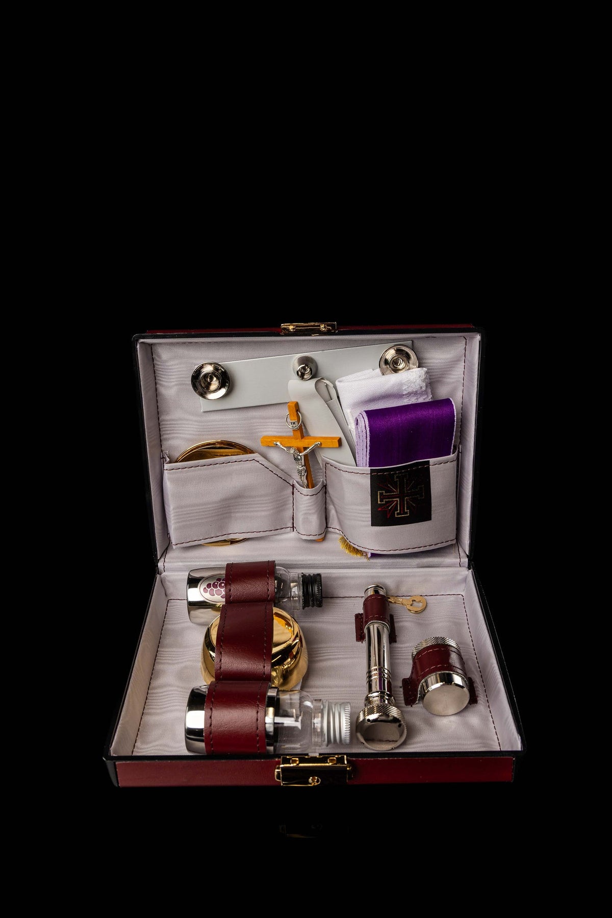 Liturgical Equipment Suitcase with Small Altar open with vessels, crucifix, linens, candles and purple cloths