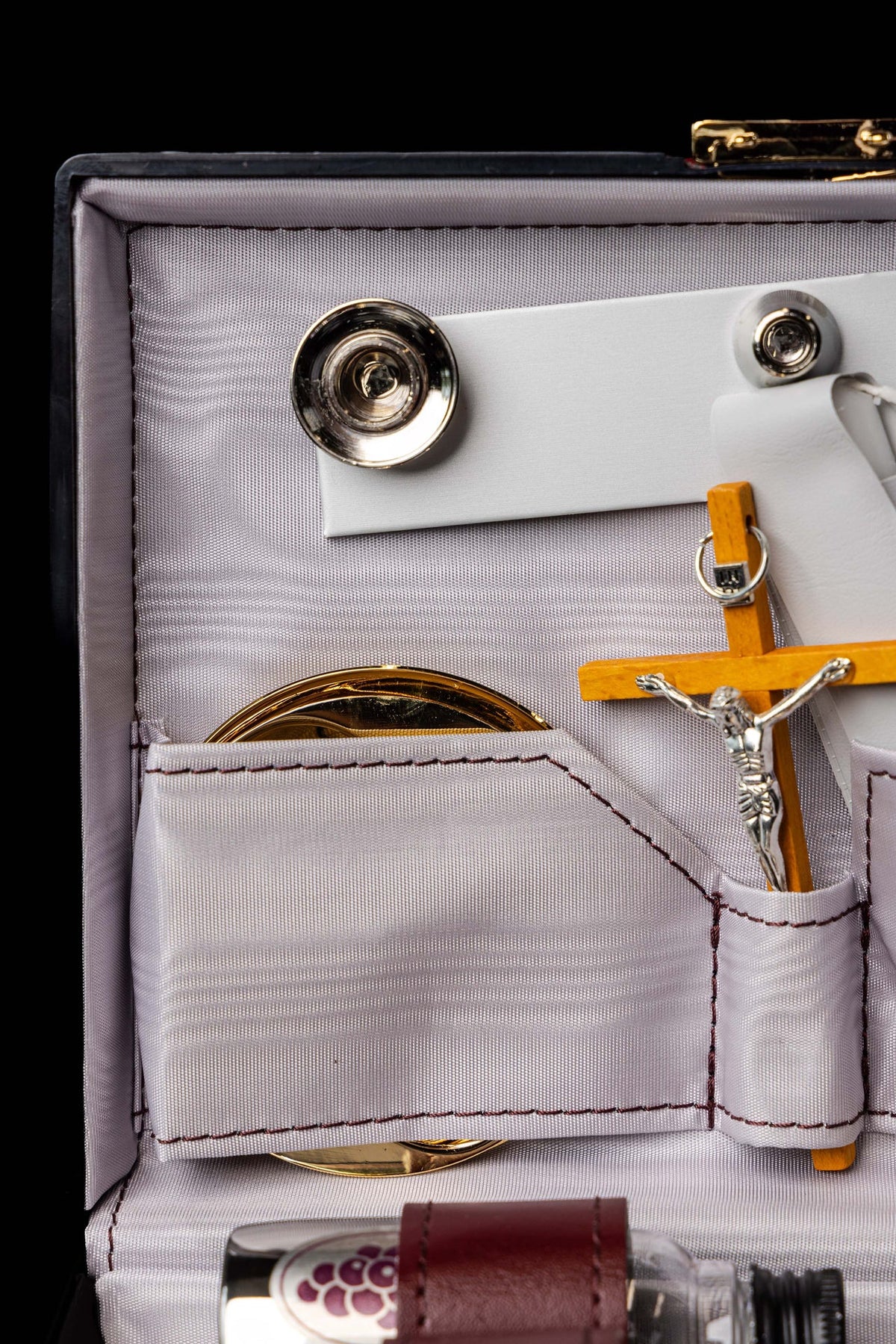 Close-up of liturgical suitcase altar fittings, gold vessel and wooden crucifix