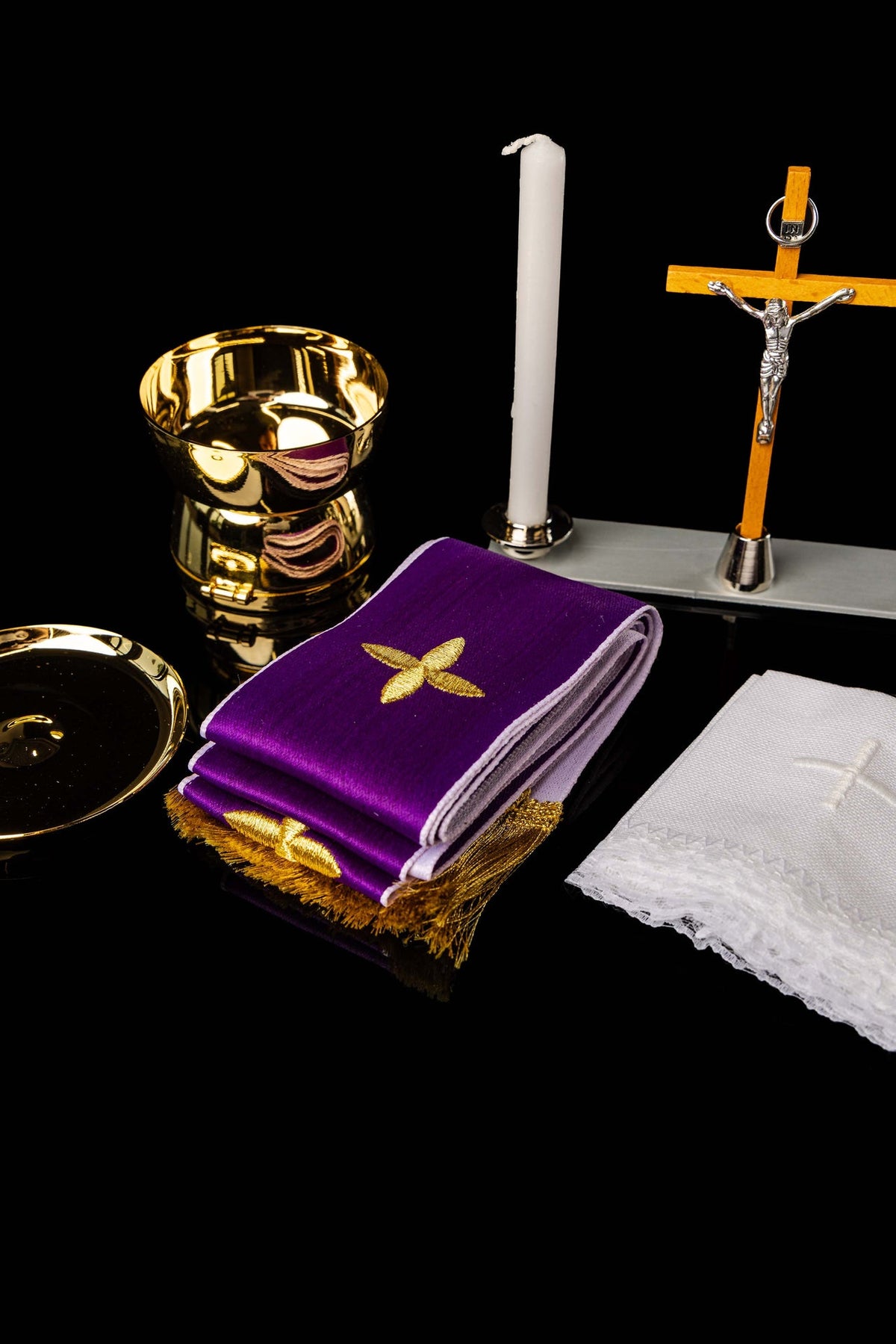 Liturgical suitcase contents with purple embroidered cloth, gold vessel, candles and crucifix