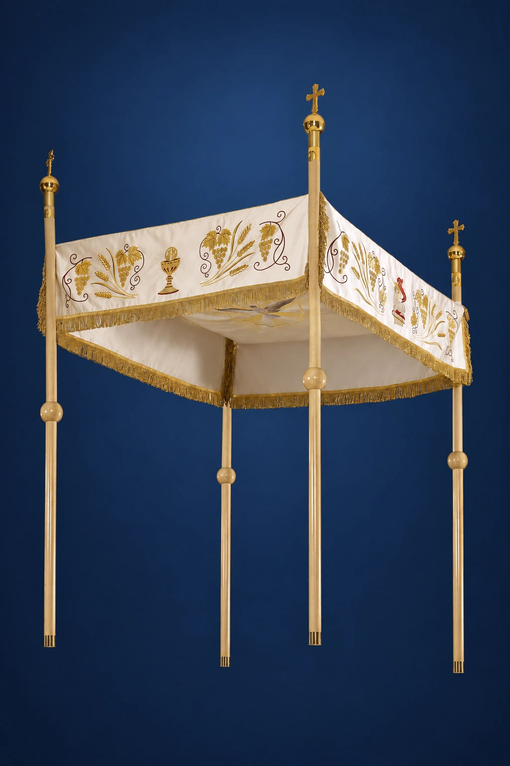 Ecru Corpus Christi canopy with gold IHS embroidery and four tall poles, shown in three-quarter view
