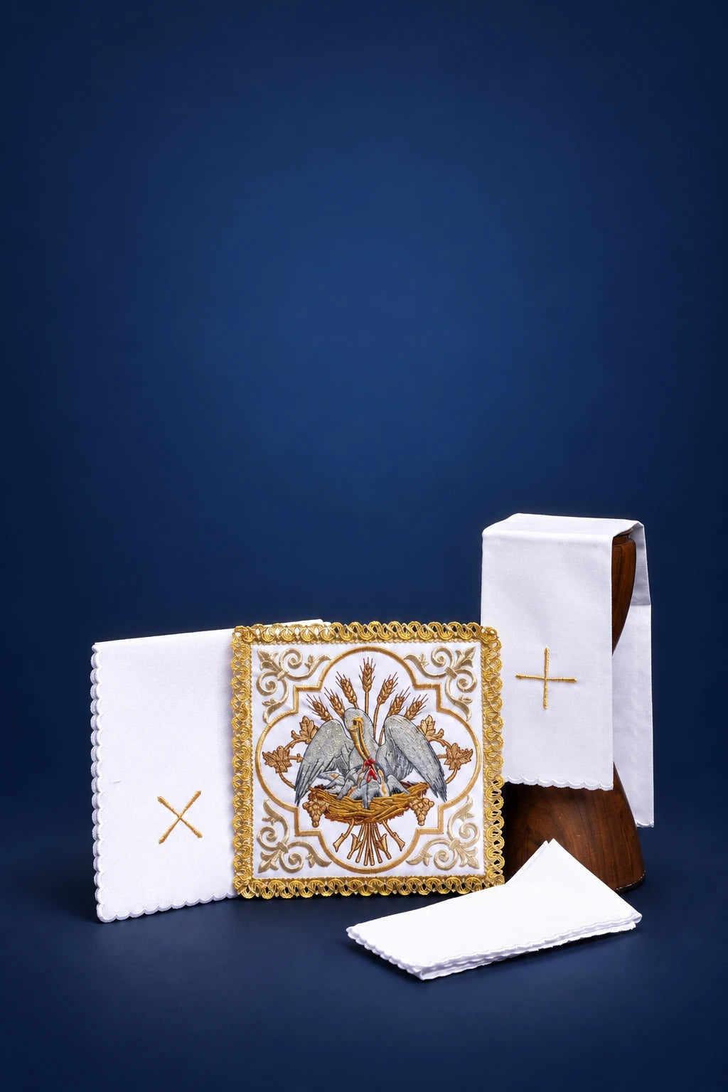 Embroidered altar linen set with pelican motif, unfolded cloths and folded purificator with gold cross and trim