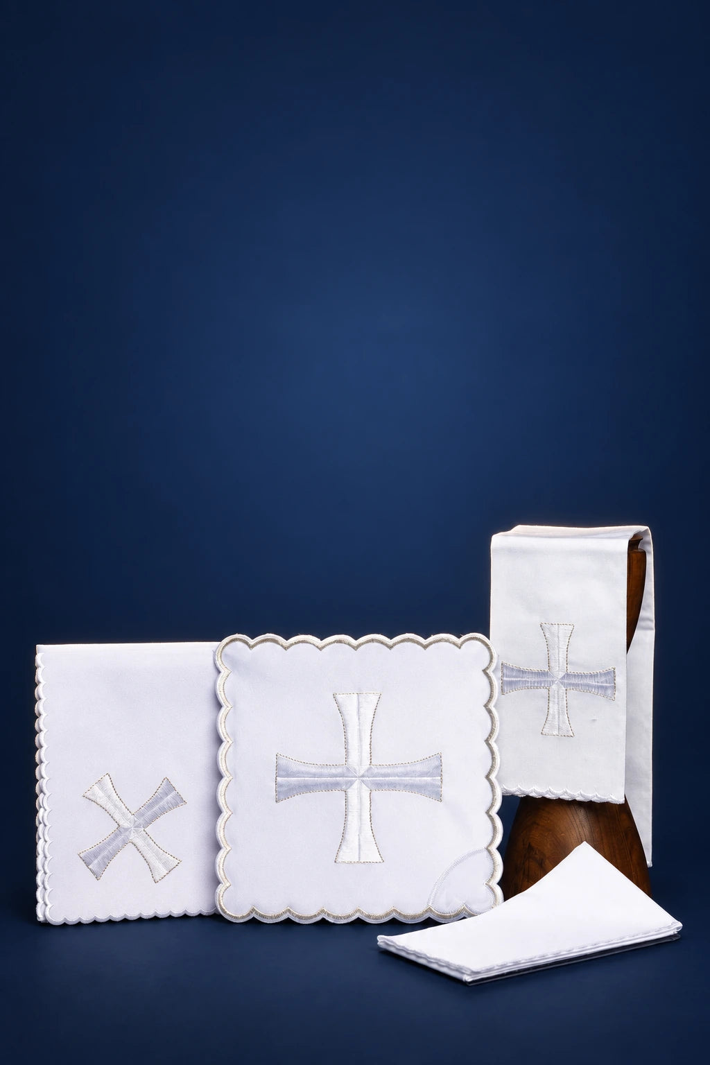 Embroidered altar linen set with silver crosses, shown folded with one square cloth and a purificator detail